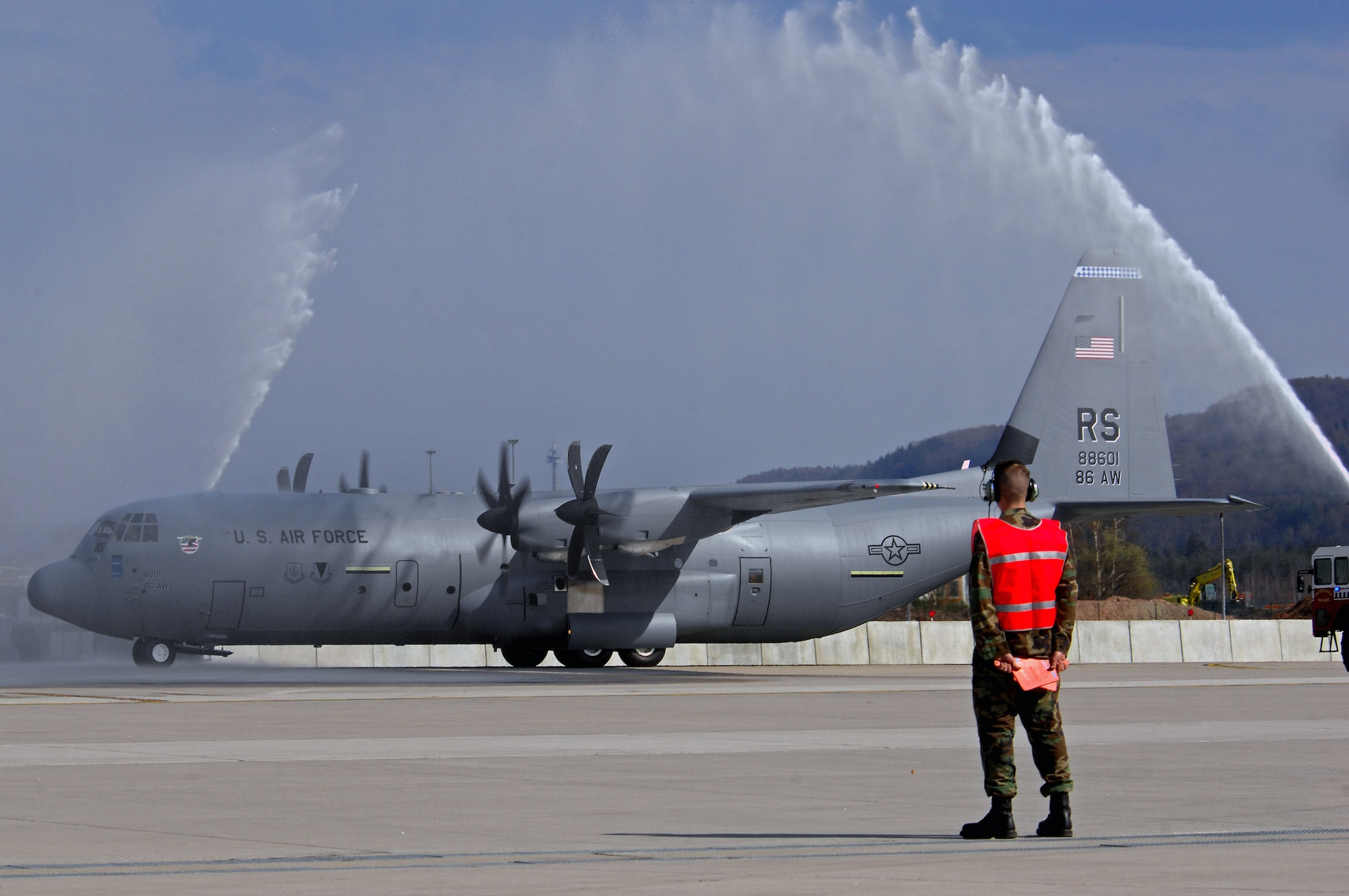 The first C-130J Super Hercules to be assigned to the Ramstein Air Base, Germany, fleet taxies under pressured water from two base fire trucks during an arrival ceremony April 7.  The aircraft's owning unit, the 86th Airlift Wing, celebrated not only the arrival of the J-model during the ceremony, but also a new era in operations for the wing. This aircraft is the first of 14 J-models that are scheduled to arrive over the next 12 months to replace the older E-model Hercules stationed at Ramstein.  (U.S. Air Force photo/Airman 1st Class Kenny Holston) 