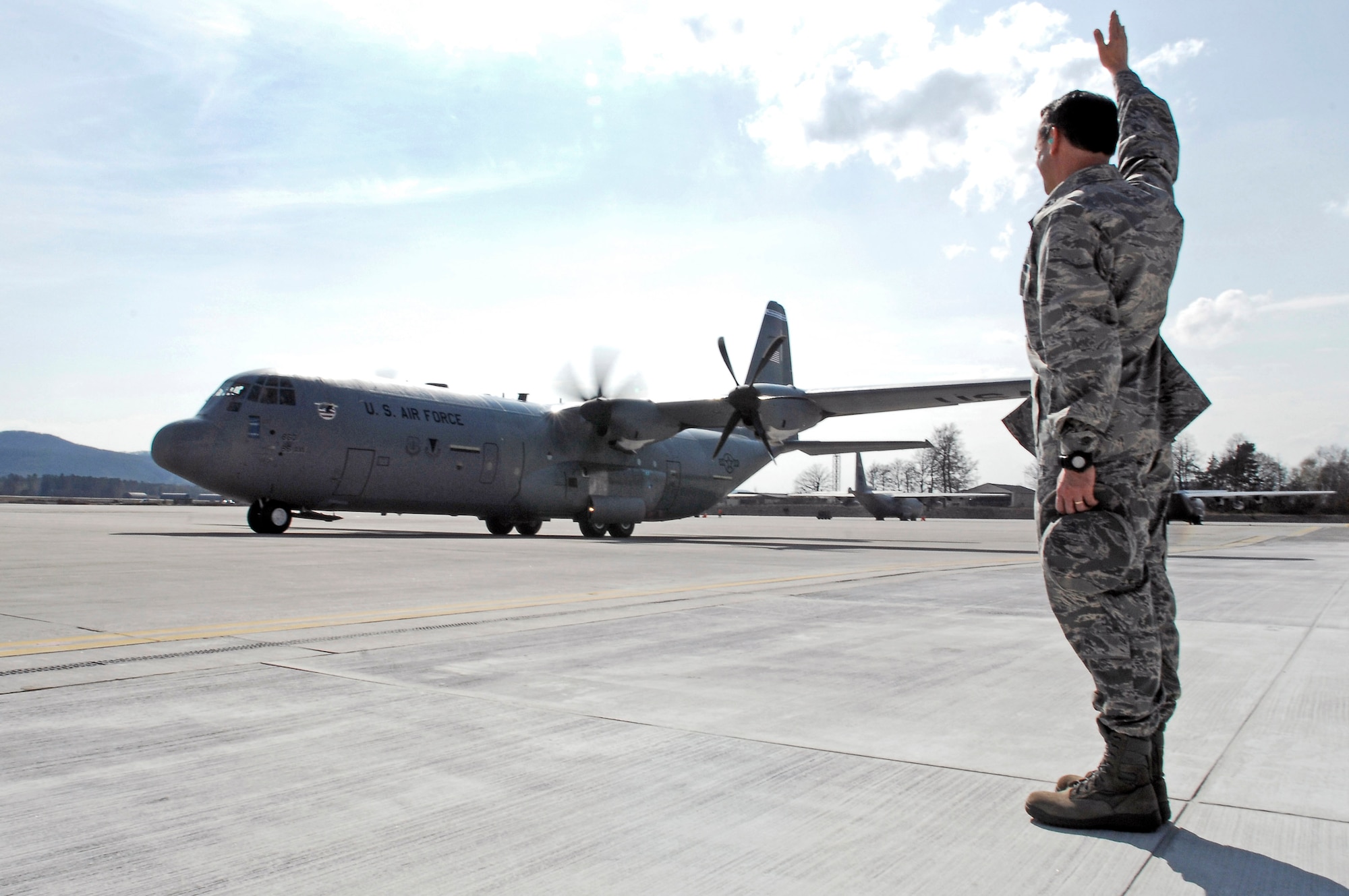 Col. Donald Bacon, 435th Air Base Wing commander at Ramstein Air Base, Germany, helps marshal the first C-130J Super Hercules to be stationed there during an arrival ceremony, April 7. The aircraft's owning unit, the 86th Airlift Wing, celebrated not only the arrival of the J-model during the ceremony, but also a new era in operations for the wing. This aircraft is the first of 14 J-models that are scheduled to arrive over the next 12 months to replace the older E-model Hercules stationed there. (U.S. Air Force photo/Senior Airman Amber Bressler)