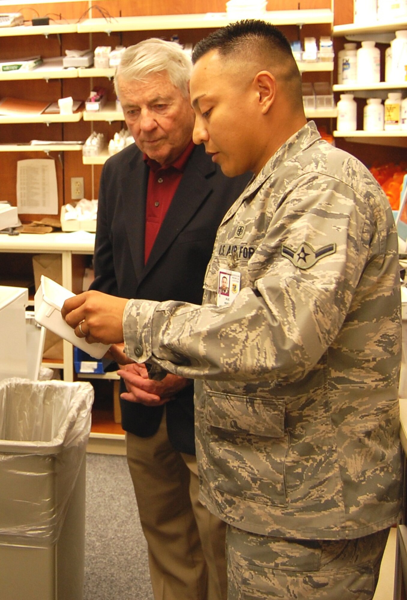 Chief Gaylor learns from Airman Hugo Agurcia-Reyes how the pharmacy uses the PharmAssist robot to fill hundreds of prescriptions each day. Airman Agurcia-Reyes is a pharmacy apprentice with the 81st Diagnostics and Therapeutics Squadron.  (U.S. Air Force photo by Steve Pivnick)