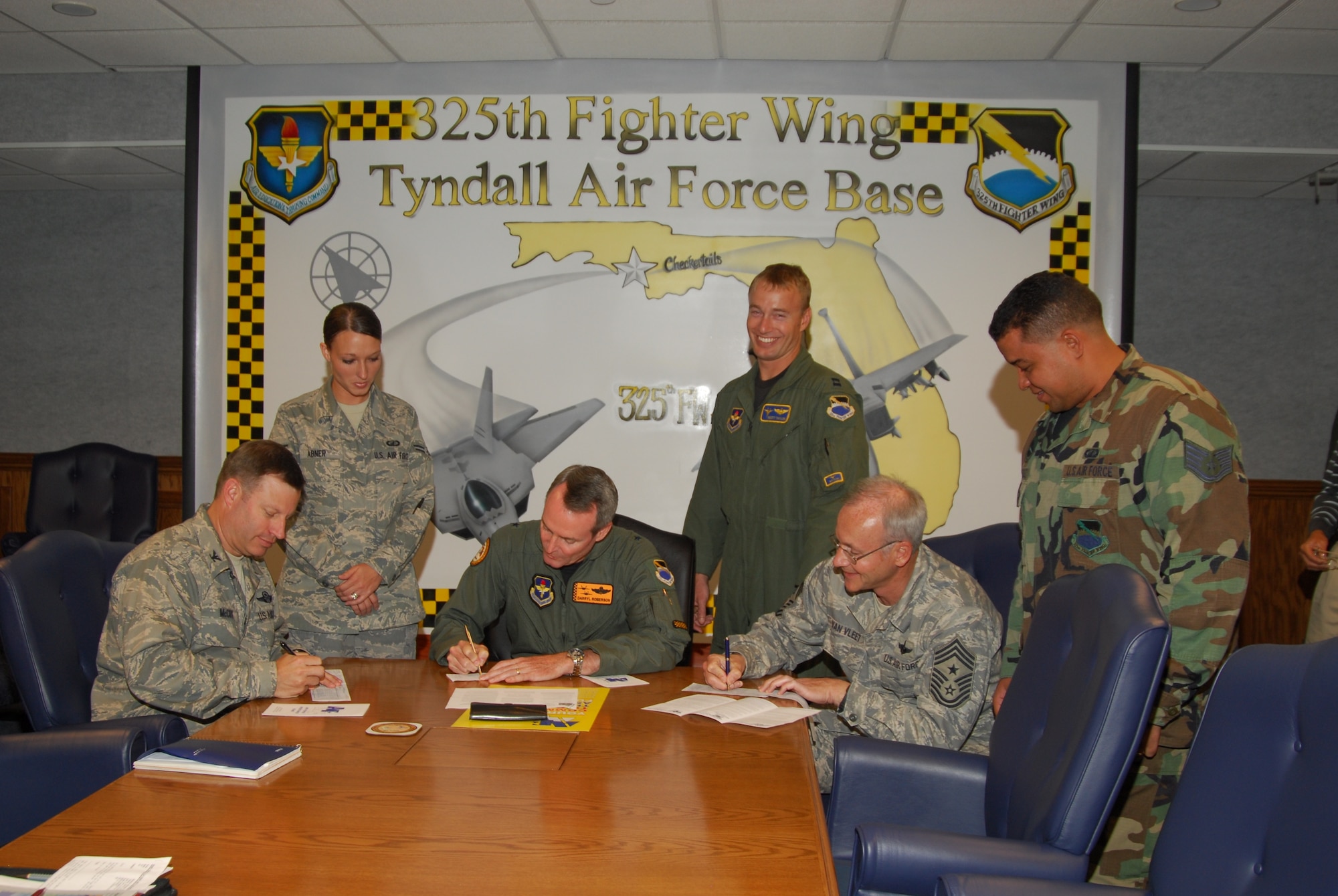 Brig. Gen. Darryl Roberson, 325th Fighter Wing commander, Col. Bradley McCoy, 325th FW vice commander and Chief Master Sgt. Benjamin Van Vleet, 325th FW command chief master sergeant sign their Air Force Assistance Fund pledges.  Team Tyndall is currently at the 59 percent mark of its 2009 $101,500 goal.  (U.S. Air Force photo by Lisa Norman)