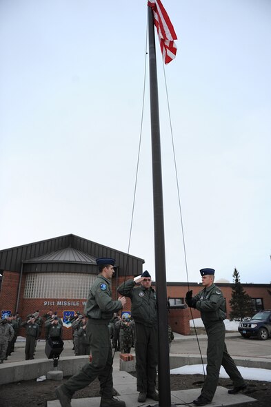 MINOT AIR FORCE BASE, N.D. – 2nd Lt. Stephen Milacci, a 741st Missile Squadron deputy missile combat crew commander, salutes the American flag after the playing of “To the Colors”, in front of the 91st Missile Wing headquarters building here, April 3. 91st MW squadrons began performing reveille as part of Col. Christopher Ayres, 91st MW commander's plan for the 'Return to Glory'. This battle cry embodies what Colonel Ayres wishes to instill in all his fellow Airmen; honor, respect and pride in everything they do. The time-honored tradition of reveille is performed every Friday morning at 7:30 a.m., and will continue until the fall. (U.S. Air Force photo by Senior Airman Kelly Timney)