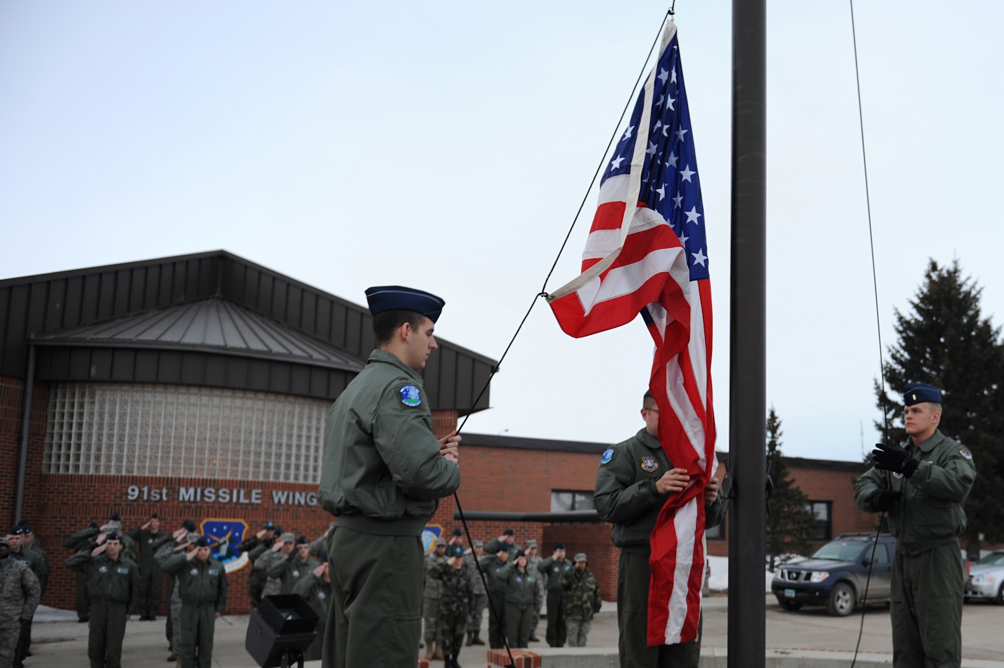 MINOT AIR FORCE BASE, N.D. -- Airmen from the 741st Missile Squadron raise the American flag briskly during the playing of “To the Colors”, in front of the 91st Missile Wing headquarters building here, April 3. 91st MW squadrons began performing reveille as part of Col. Christopher Ayres, 91st MW commander's plan for the 'Return to Glory'. This battle cry embodies what Colonel Ayres wishes to instill in all his fellow Airmen; honor, respect and pride in everything they do. The time-honored tradition of reveille is performed every Friday morning at 7:30 a.m., and will continue until the fall. (U.S. Air Force photo by Senior Airman Kelly Timney)