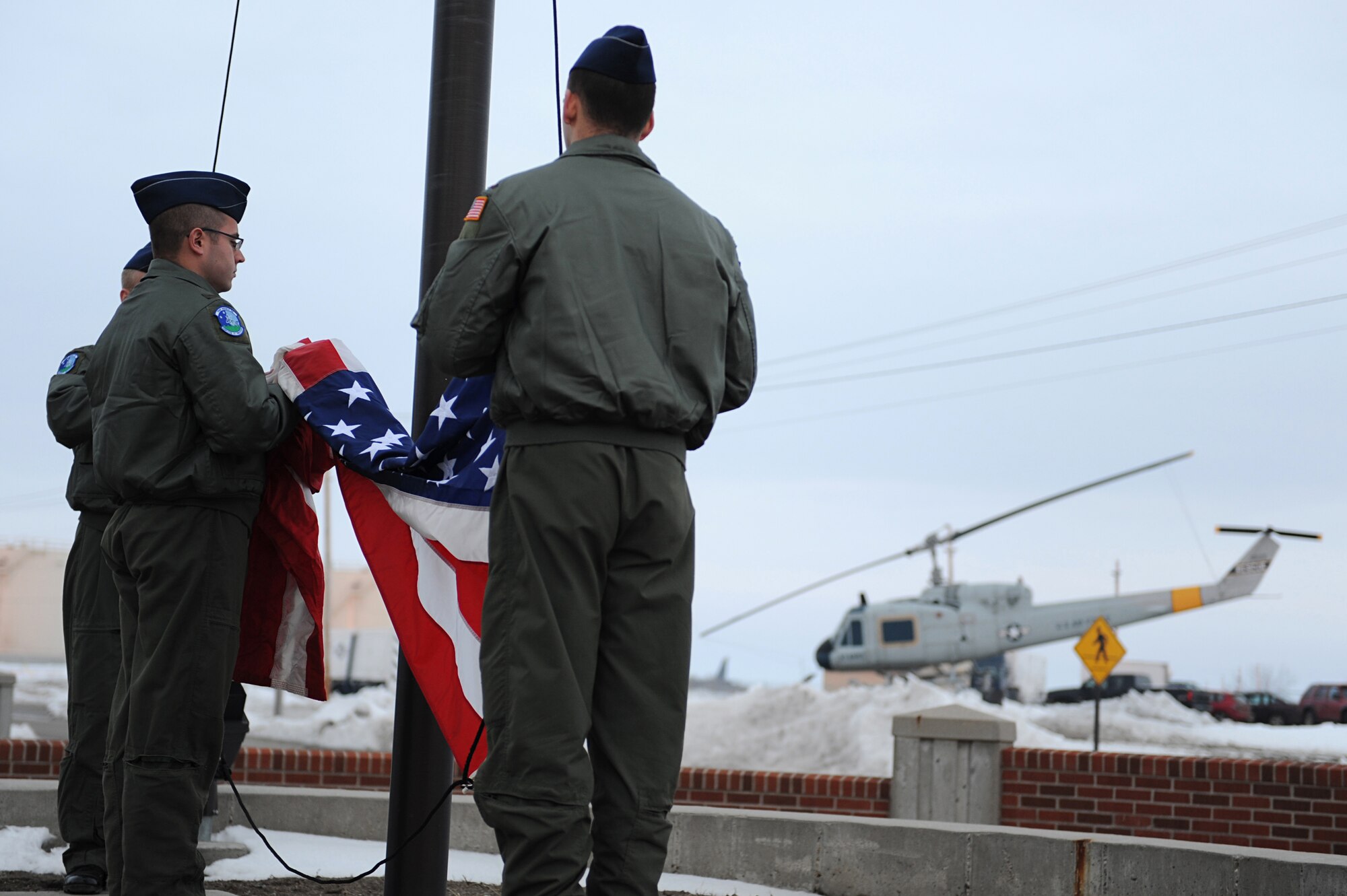 MINOT AIR FORCE BASE, N.D. -- Airmen from the 741st Missile Squadron attaches the American flag to the halyards during reveille in front of the 91st Missile Wing headquarters building here, April 3. 91st MW squadrons began performing reveille as part of Col. Christopher Ayres, 91st MW commander's plan for the 'Return to Glory'. This battle cry embodies what Colonel Ayres wishes to instill in all his fellow Airmen; honor, respect and pride in everything they do. The time-honored tradition of reveille is performed every Friday morning at 7:30 a.m., and will continue until the fall. (U.S. Air Force photo by Senior Airman Kelly Timney)