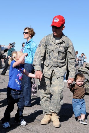Staff Sgt. Brad Wagner from the 820th RED HORSE Squadron holds hands with his four year old daughter, Jillian, and 18 month old son, Colby, upon arrival after a seven-month deployment in Southwest Asia, April 6, Nellis Air Force Base, Nev. RED HORSE squadrons provide the Air Force with a highly-mobile civil engineering capability in support of the contingency and special operations worldwide.(U.S. Air Force photo by Airman 1st Class Brett Clashman/Released)