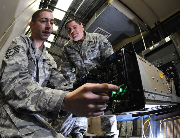 Staff Sgt. Anthony Villalpando and Moises Guzman, 99th Communications Squadron ground radar systems technicians, perform maintenance repairs on a TPX42 radar system at Nellis Air Force Base, Nev., Apr. 1.(U.S. Air Force photo by Senior Airman Larry E. Reid Jr.)