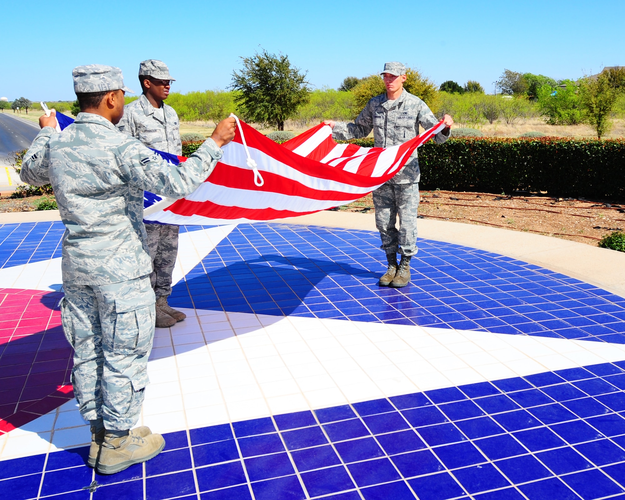 DYESS AIR FORCE BASE, Texas - Members of the Dyess honor guard prepare to fold the flag here April 3.  The flag folding ceremony was part of the base retreat. A flyover by a B-1 was part of the ceremony. (U.S. Air Force photo by Staff Sgt. Alan Garrison)