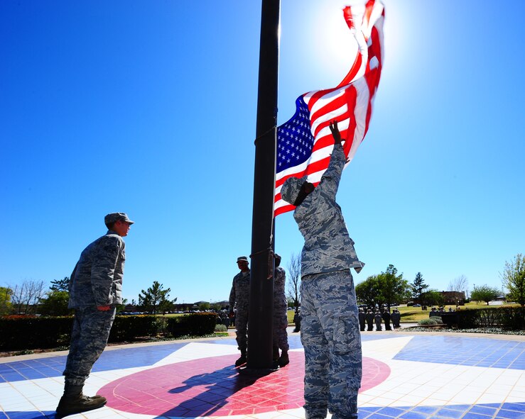 DYESS AIR FORCE BASE, Texas - A member of the Dyess Honor Guard retrieves the flag during a base retreat ceremony here April 3.  The ceremony was attended by personell from multiple units at Dyess.