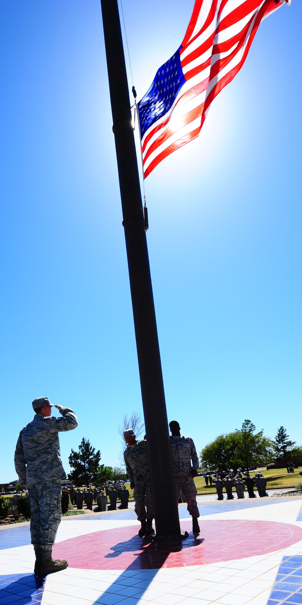 DYESS AIR FORCE BASE, Texas - Members of team Dyess render a salute while members of the Dyess Honor Guard retreive the flag here April 3. T (U.S. Air Force photo by Staff Sgt Alan Garrison)