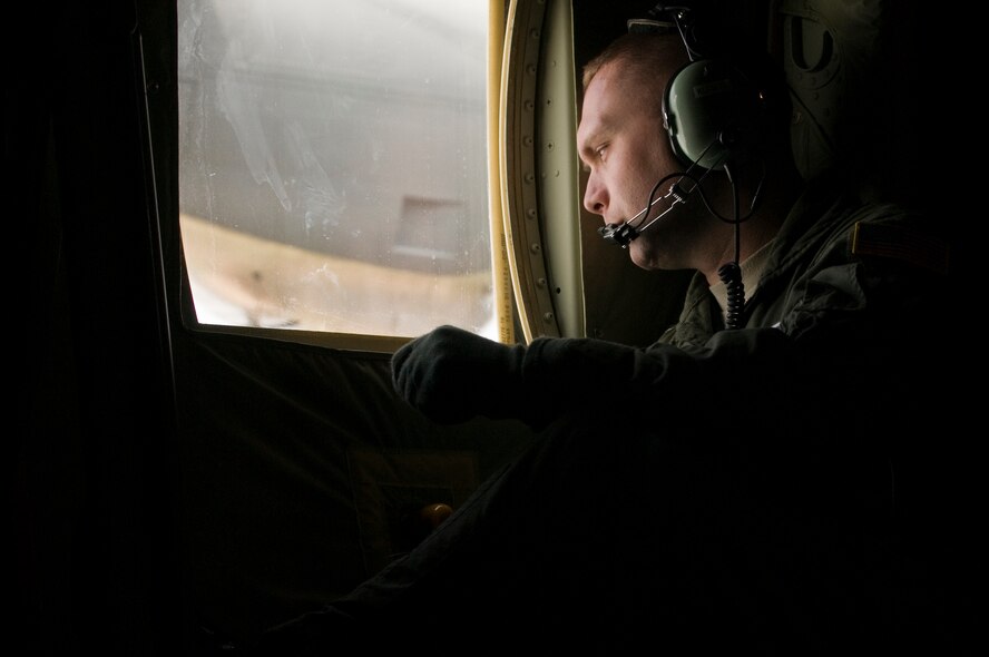Master Sgt. Jason Kunkel, 37th Airlift Squadron loadmaster, peers out the window of the wing's new C-130J during its flight to Ramstein Air Base April 7. The J-model provides approximately 20 percent improvements over previous C-130 models in speed, fuel efficiency, cargo capacity and altitude capabilities.  (U.S. Air Force photo by Senior Airman Nathan Lipscomb)
