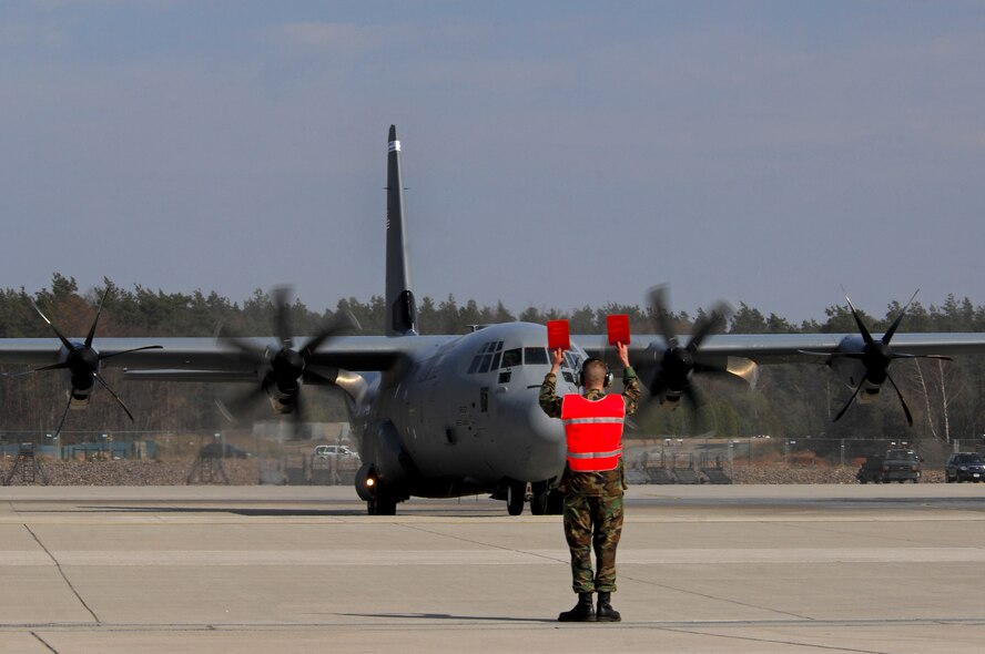 A member of the 86th Maintenance Squadron marshals the first U.S. Air Force C-130J to be assigned to the Ramstein Air Base fleet, April 7, 2009. The C-130J landed on Ramstein for the first time during a ceremony today held to not only honor the arrival of the new aircraft, but also a new era in operations for the 86th Airlift Wing. The ceremony also included a ribbon cutting for a new 68,000 square feet dual-bay maintenance hangar, which can hold two C-130J aircraft or one C-17.  (U.S. Air Force photo by Airman 1st Class Kenny Holston)