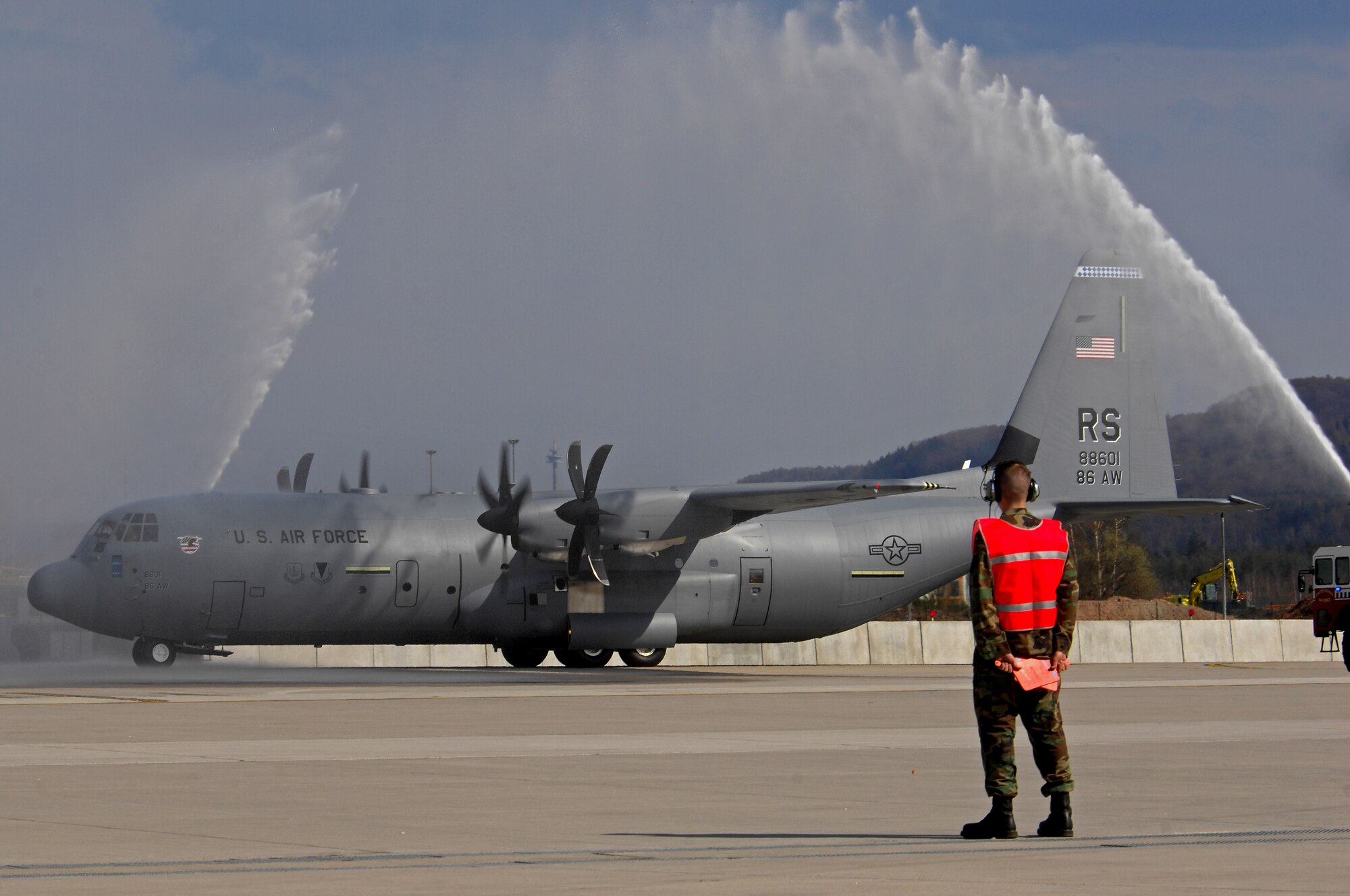 The first U.S. Air Force C-130J to be assigned to the Ramstein Air Base fleet taxies under pressured water from two Ramstein fire trucks during a celebration ceremony, April 7, 2009. The J-model landed on Ramstein for the first time during a ceremony today held to not only honor the arrival of the new aircraft, but also a new era in operations for the 86th Airlift Wing. The ceremony also included a ribbon cutting for a new 68,000 square feet dual-bay maintenance hangar, which can hold two C-130J aircraft or one C-17.  (U.S. Air Force photo by Airman 1st Class Kenny Holston)