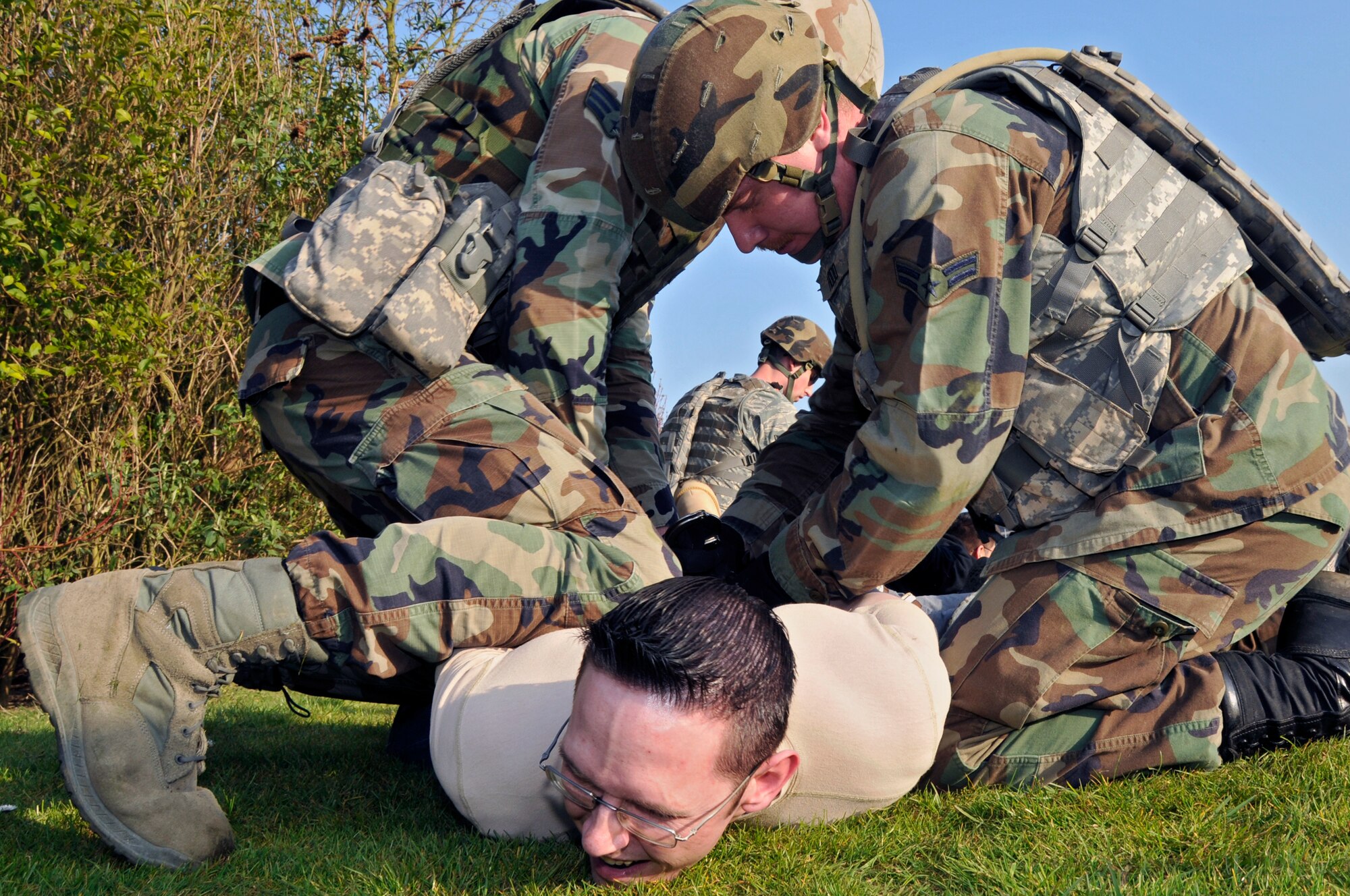 ROYAL AIR FORCE FELTWELL, England -- 48th Security Forces Squadron Airmen handcuff a member of the opposing force, after a surprise attack here April 2, 2009. Airmen from the 48th SFS participated in an air base defense exercise. The training is an annual requirement for the squadron. (U.S. Air Force photo by Airman 1st Class Perry Aston) (Released)