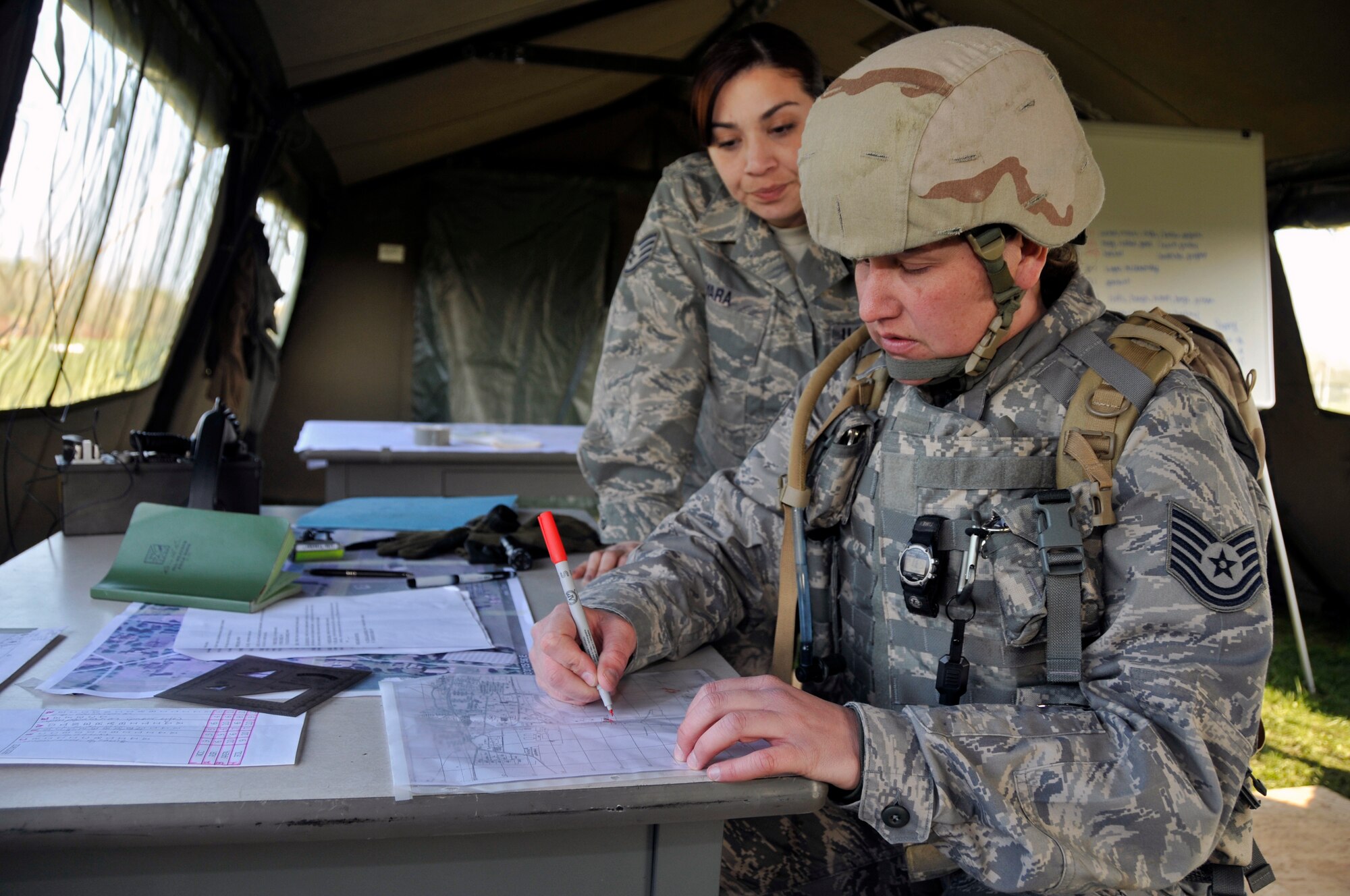 ROYAL AIR FORCE FELTWELL, England -- Staff Sgt. Shireen Yara, 48th Security Forces Squadron, watches Tech. Sgt. Tina Harem, 48th SFS map out the location of the defensive fighting position here April 2, 2009. Airmen from the 48th Security Forces Squadron had to build defensive fighting positions as part of their annual air base defense training. (U.S. Air Force photo by Airman 1st Class Perry Aston) (Released)