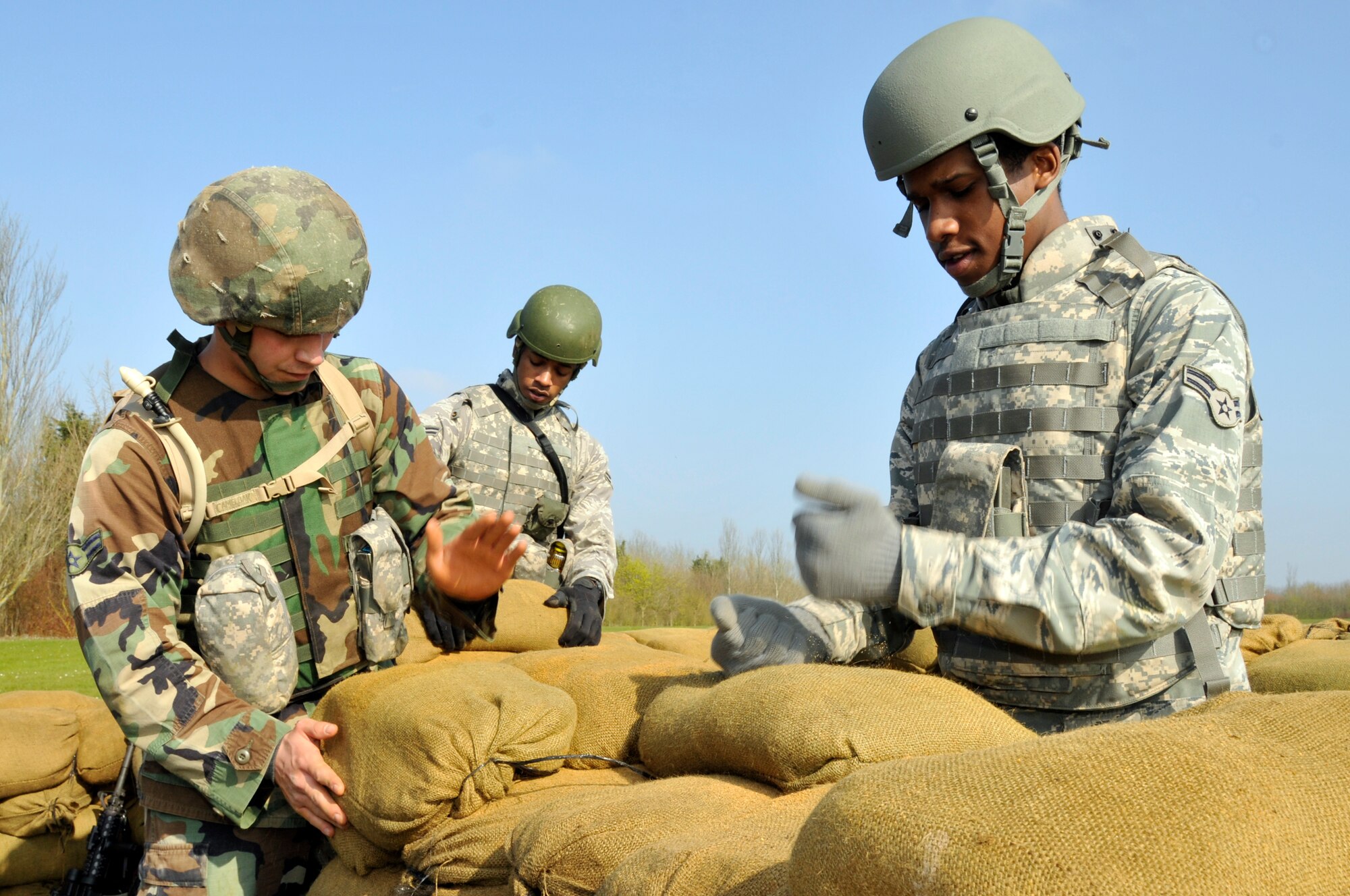 ROYAL AIR FORCE FELTWELL, England -- Airman 1st Class Arturo Rivero, Airman 1st Class Melvin Walker, and Airman 1st Class Dewight Goforth, 48th Security Forces Squadron, build a defensive fighting position here, April 2, 2009 Airmen from the 48th SFS built these positions as part of their annual air base defense training. (U.S. Air Force photo by Airman 1st Class Perry Aston) (Released)  