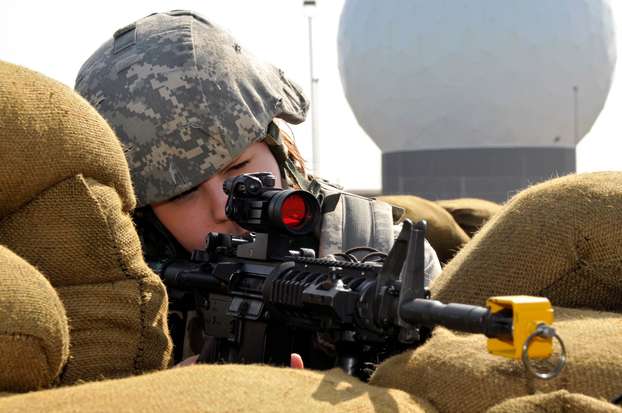 ROYAL AIR FORCE FELTWELL, England -- Airman 1st Class Emily Redford, 48th Security Forces Squadron, keeps a watchful eye for any possible combatants that may out of the wood line while her fellow Airmen build up the defensive fighting position here April 2, 2009. Airmen from the 48th Security Forces Squadron built these positions as part of their annual air base defense training. (U.S. Air Force photo by Airman 1st Class Perry Aston) (Released) 