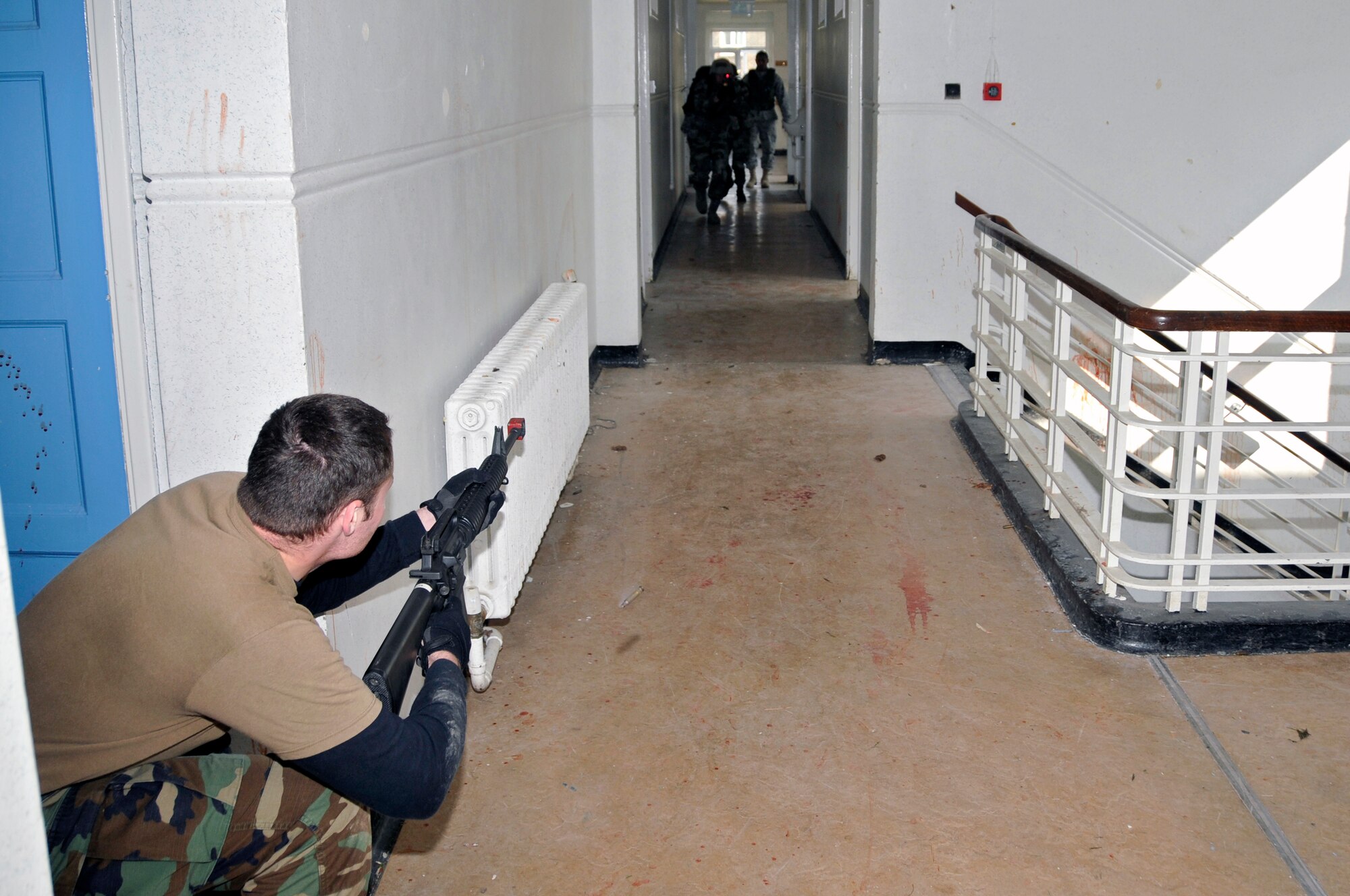 ROYAL AIR FORCE FELTWELL, England -- An opposing force member fires at 48th Security Forces Squadron Airmen making their way down the hall here April 2, 2009. Airmen from the 48th SFS participated in an air base defense exercise. The training is an annual requirement for the squadron. (U.S. Air Force photo by Airman 1st Class Perry Aston) (Released)