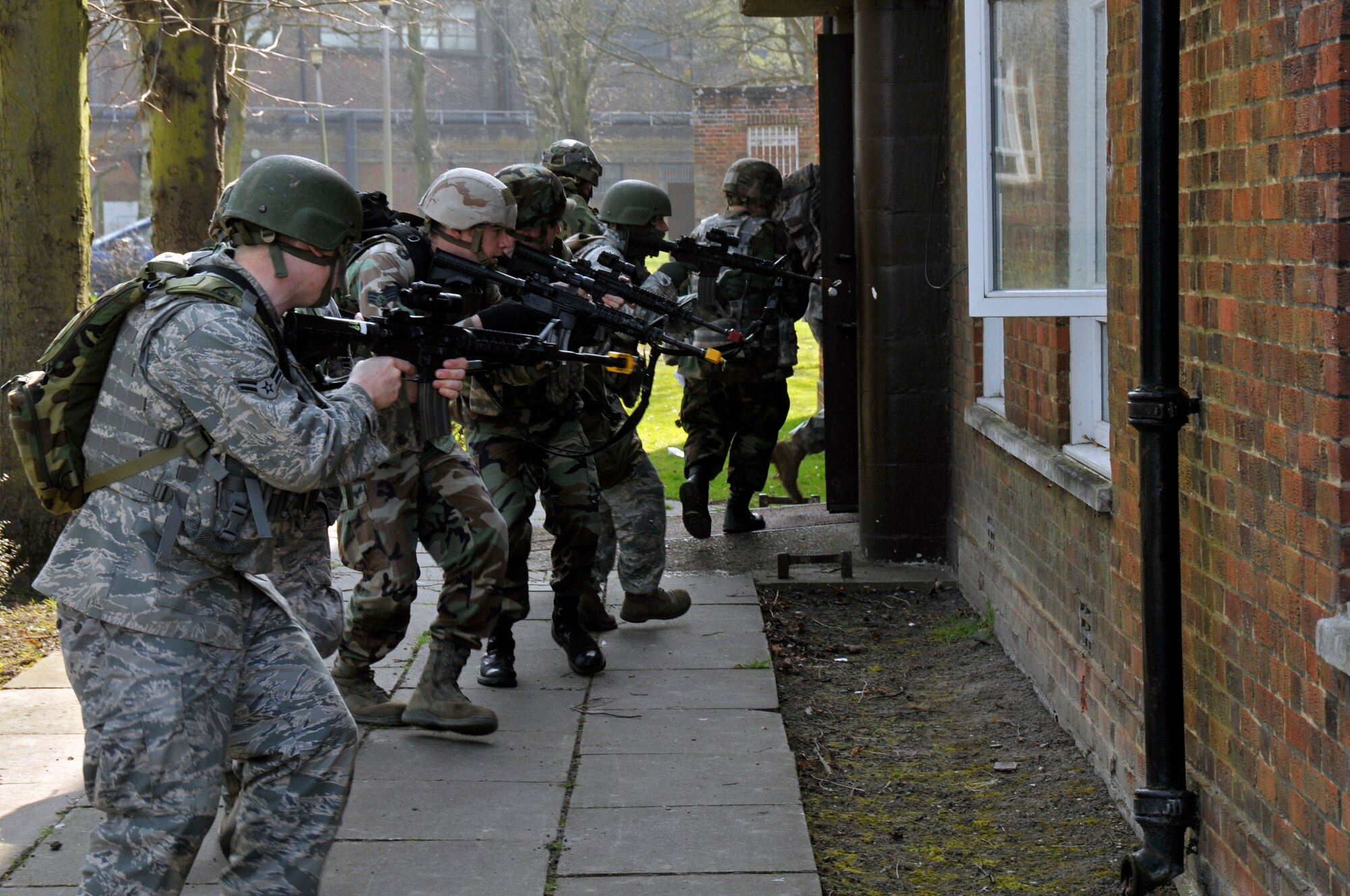 ROYAL AIR FORCE FELTWELL, England -- 48th Security Forces Squadron Airmen storm a building suspected of being occupied by members of an opposing force here April 2, 2009. Airmen from the 48th SFS participated in an air base defense exercise. The training is an annual requirement for the squadron. (U.S. Air Force photo by Airman 1st Class Perry Aston) (Released)