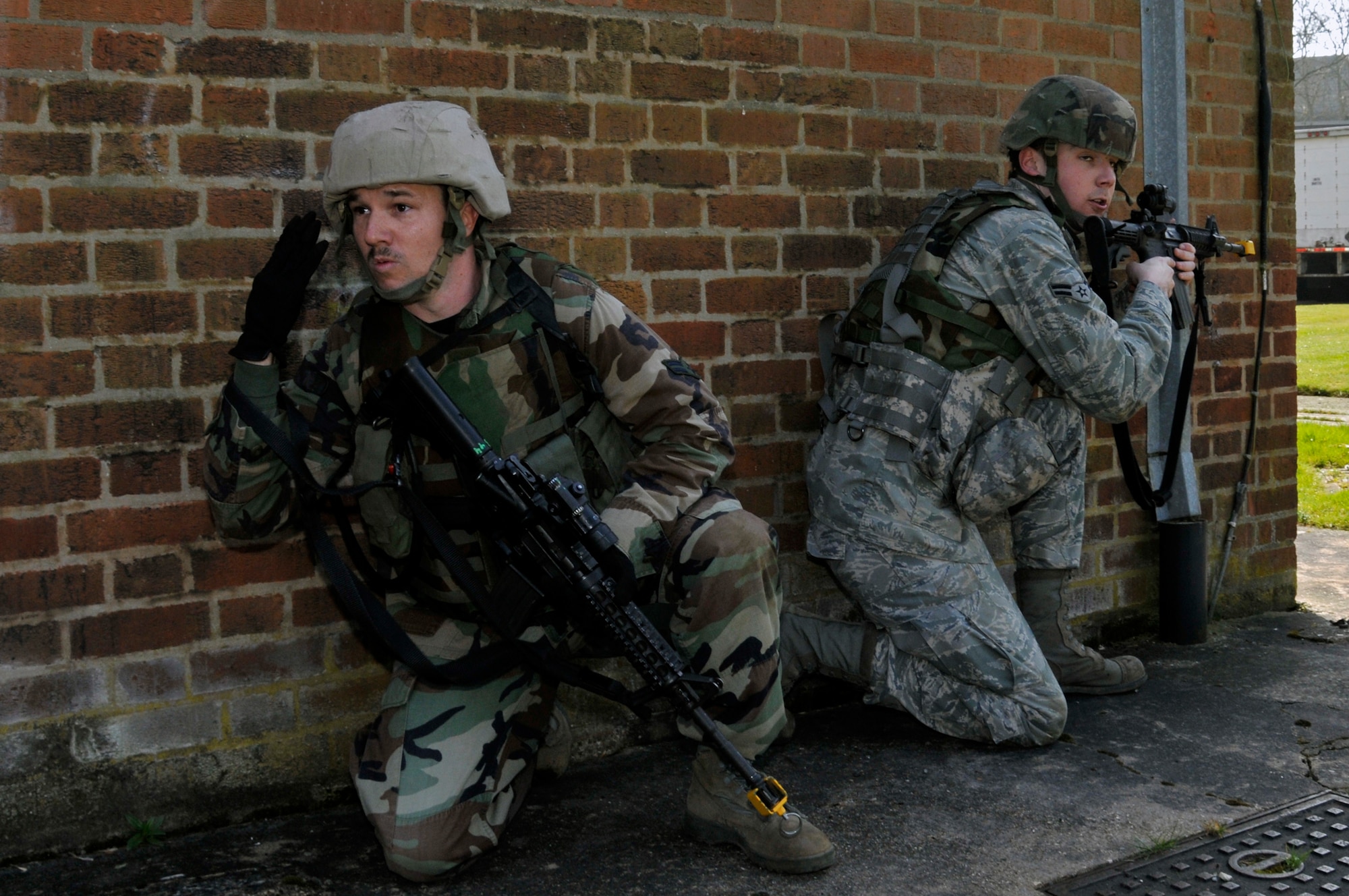 ROYAL AIR FORCE FELTWELL, England -- Airman 1st Class Chad McCambridge, 48th Security Forces Squadron, signals for the rest of his team to move to his position while Airman 1st Class Ryan Gregory 48th SFS, stays on the lookout for the enemy here April 2, 2009. Airmen from the 48th SFS participated in an air base defense exercise. The training is an annual requirement for the squadron. (U.S. Air Force photo by Airman 1st Class Perry Aston) (Released)