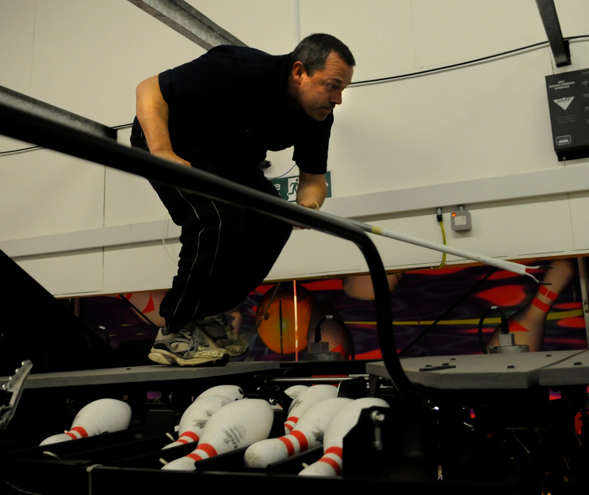 Steve Girod, assistant mechanic, resets a bowling pin recycler at the RAF Mildenhall bowling center April 3.  Steve is a self-taught equipment mechanic who is part of a two-man team that keeps the bowling alley equipment running smoothly.  (U.S. Air Force photo by Senior Airman Christopher L. Ingersoll)