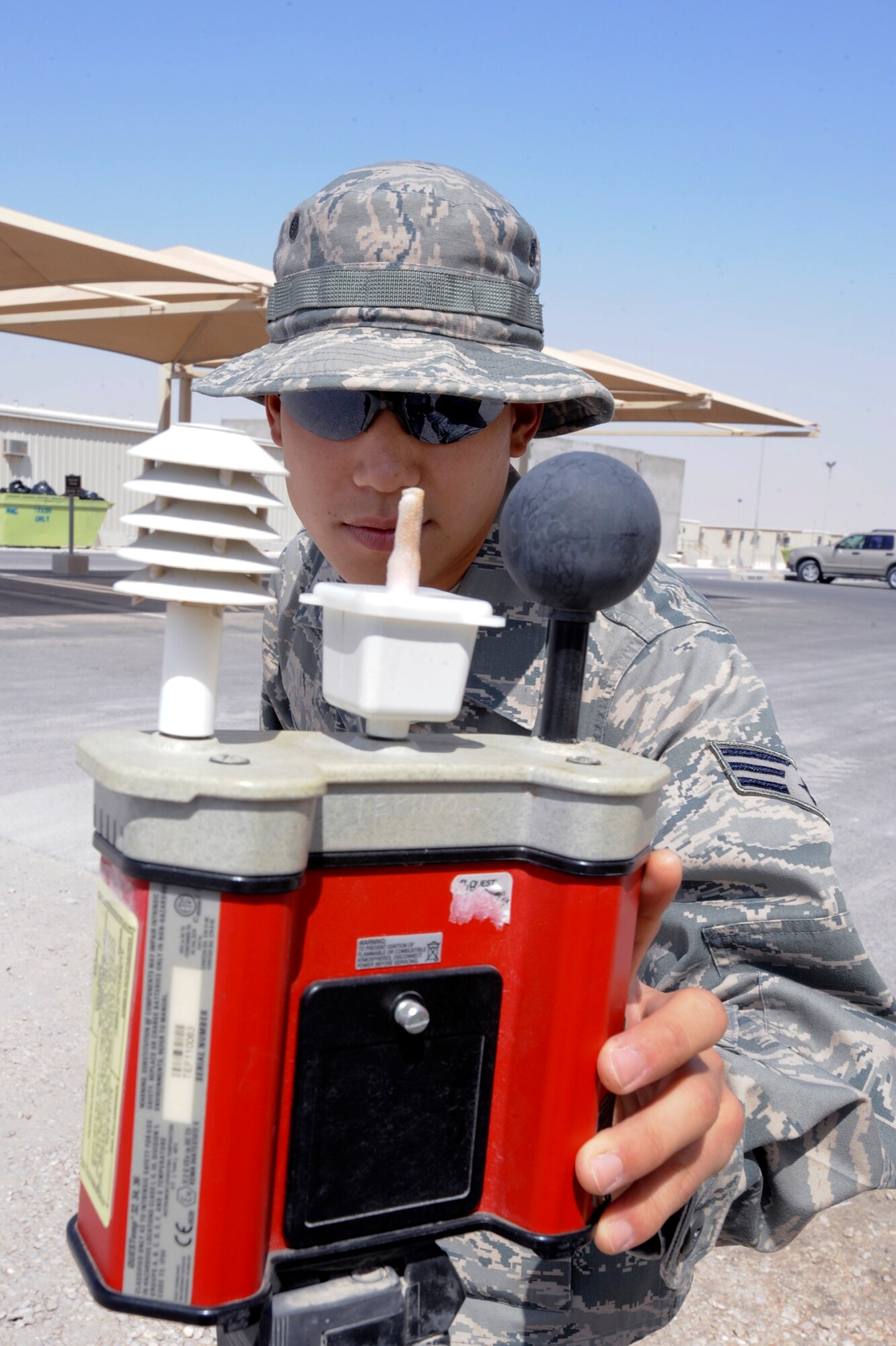 Senior Airman Andrew Kim, a bio-environmental engineering technician with the 379th Medical Group, checks the temperature reading from a Wet Ball Globe Thermometer, April 7, 2009, in an undisclosed location in Southwest Asia.  The WBGT provides a composite temperature used to estimate the effects of temperature, humidity, wind speed (wind chill) and solar radiation on humans.  Airman Kim is native to Walnut, Calif. and is deployed from Keesler Air Force Base, Miss., in support of Operations Iraqi and Enduring Freedom and Combined Joint Task Force - Horn of Africa.  (U.S. Air Force Photo by Staff Sgt. Joshua Garcia/released)