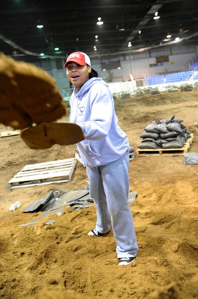 MINOT, N.D. – Senior Airman Sharida Jackson, 5th Bomb Wing Public Affairs photographer, spends her afternoon helping fill sand bags to aid in flood relief efforts, April1. Minot area volunteers from the community and Minot Air Force Base reached their goal of filling 25,000 sandbags in the first two days alone. Minot AFB has been in the thick of the fight with flood efforts the past few weeks, whether it be augmenting support forces at Grand Forks AFB, N.D., or sending helicopters and rescue equipment to Fargo or Bismarck, N.D.  (U.S. Air Force photo by Senior Airman Kelly Timney)