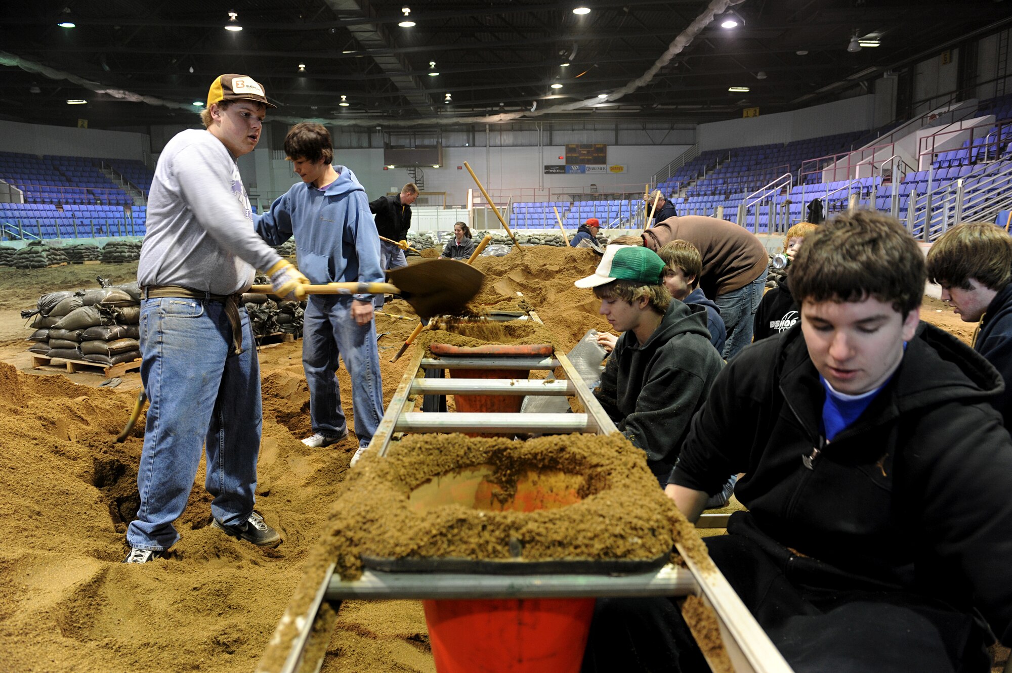 MINOT, N.D. – Members from the Bishop Ryan High School varsity baseball team help fill sand bags in Minot city’s All Season’s Arena, April 1. Volunteers from all over the community banded together to help reach the goal of filling 25,000 sandbags in the first two days alone. (U.S. Air Force photo by Senior Airman Kelly Timney)