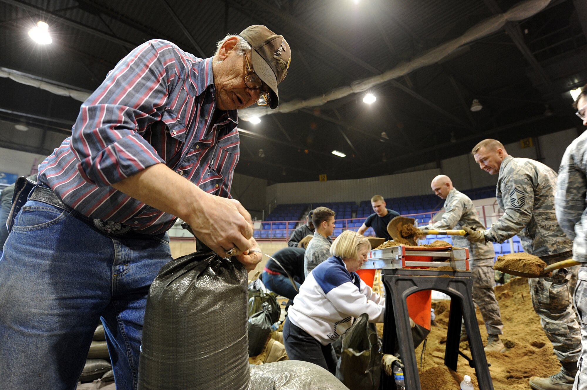 MINOT AIR FORCE BASE, N.D. –Cecil Alg, Ret. National Guard member, helps fellow Minot residents build sand bags to aid in the flood relief effort, April1.  Minot Area volunteers from the community and Minot Air Force Base reached their goal of filling 25,000 sandbags in the first two days alone, they will continue to until 1800hrs Saturday, April 4. 2009 was a year that brought progress and a renewed emphasis on safe, secure and reliable nuclear operations. The 91st Missile Wing transitioned to Air Force Global Strike Command with the 5th Bomb Wing scheduled to follow suit in 2010. (U.S. Air Force photo by Senior Airman Kelly Timney)