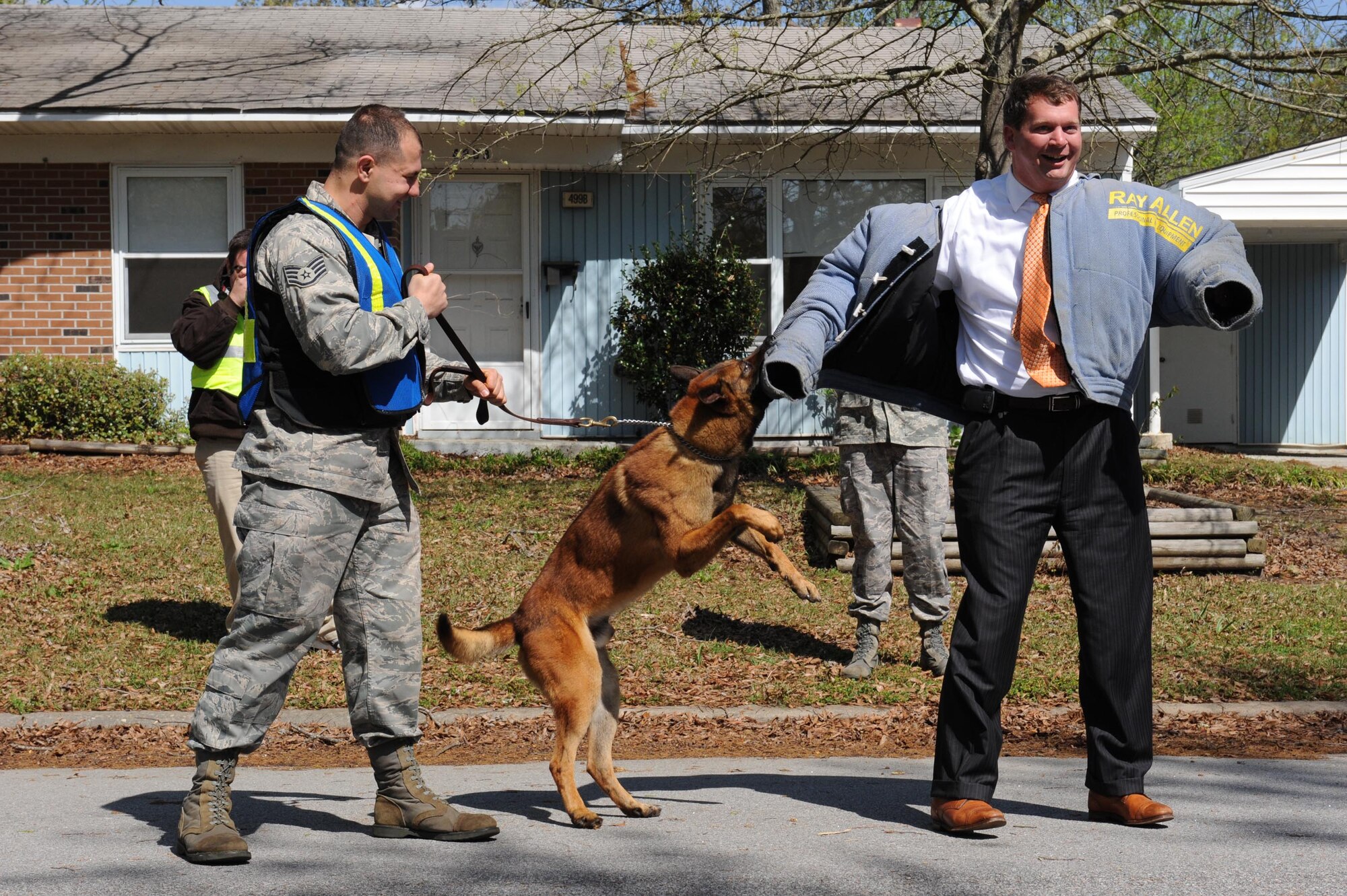 SHAW AIR FORCE BASE, S.C. -- Staff Sergeant Chris LeBlanc, 20th Security Forces K-9 dog handler, and his military working dog, Zorba, demonstrate use of force by letting Dean McCormick, Sumter city manager, wear a protective outer garment April 4, 2009. The Sumter County Police Department and Shaw Airmen utilized older base housing for police training scenarios. (U.S. Air Force photo/Senior Airman Matt Davis)