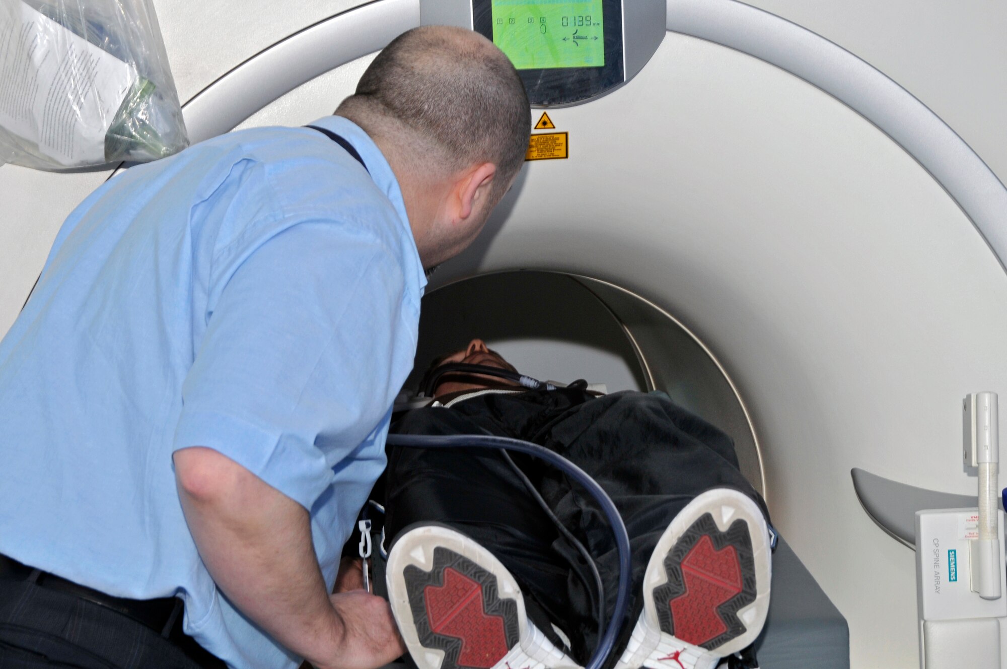 ROYAL AIR FORCE LAKENHEATH, England -- John McWilliams, InHealth MRI technician, positions Tech Sgt. Christopher Campbell 48th Fighter Wing Public Affairs NCO-in charge of internal operations here March 31, 2009. Sergeant Campbell had a MRI scan performed on his injured shoulder. (U.S. Air Force photo by Airman 1st Class Perry Aston) (Released)