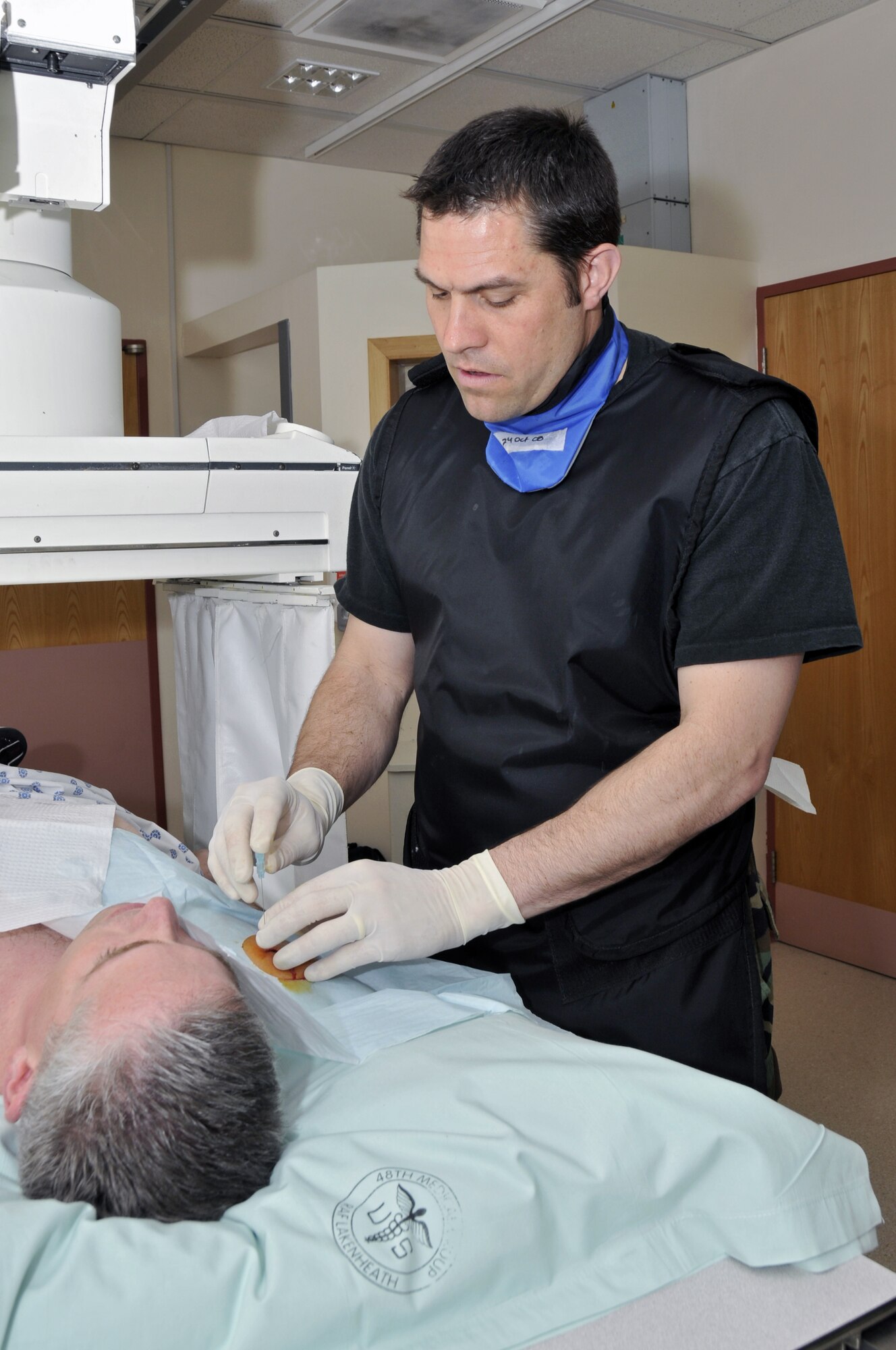 ROYAL AIR FORCE LAKENHEATH, England -- Major Douglas White, 48th Medical Operations Squadron is inserting a spinal needle into the shoulder joint of Tech Sgt. Christopher Campbell 48th Fighter Wing Public Affairs NCO-in charge of internal operations, in preparation for injecting contrast into the shoulder joint here March 31, 2009. Sergeant Campbell had a MRI scan performed on his injured shoulder. (U.S. Air Force photo by Airman 1st Class Perry Aston) (Released)