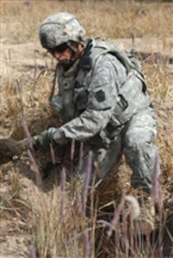 U.S. Army Sgt. Timothy Kyle from the 2nd Brigade Combat Team, 1st Infantry Division digs in a site of possible weapons caches in the city of Abu Ghraib, Iraq, on March 21, 2009.  