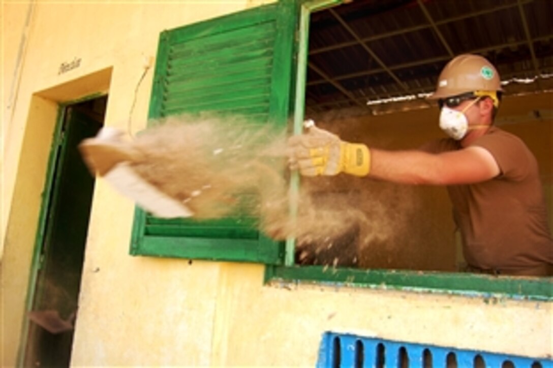 U.S. Navy Seaman Recruit David Kelly removes debris at Ecole Ali Sabieh Primary School, Ali Sabieh, Dijbouti, April 4, 2009. Kelly is a builder constructionman recruit assigned to Naval Mobile Construction Battalion 11, Detachment Horn of Africa. The battalion is repairing facilities at the school and building a new dining facility during part of a six-month deployment to the Combined Joint Task Force-Horn of Africa area of responsibility.