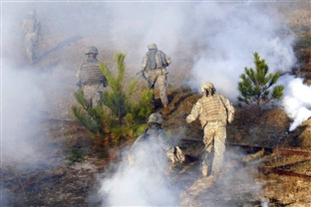 U.S. Army soldiers proceed over a dirt berm and under the cover of smoke at a training range during an air-assault, live-fire exercise on Fort Bragg, N.C., April 3, 2009. The soldiers are assigned to the 82nd Airborne Division's Company C, 2nd Battalion, 504th Parachute Infantry Regiment, 1st Brigade Combat Team.