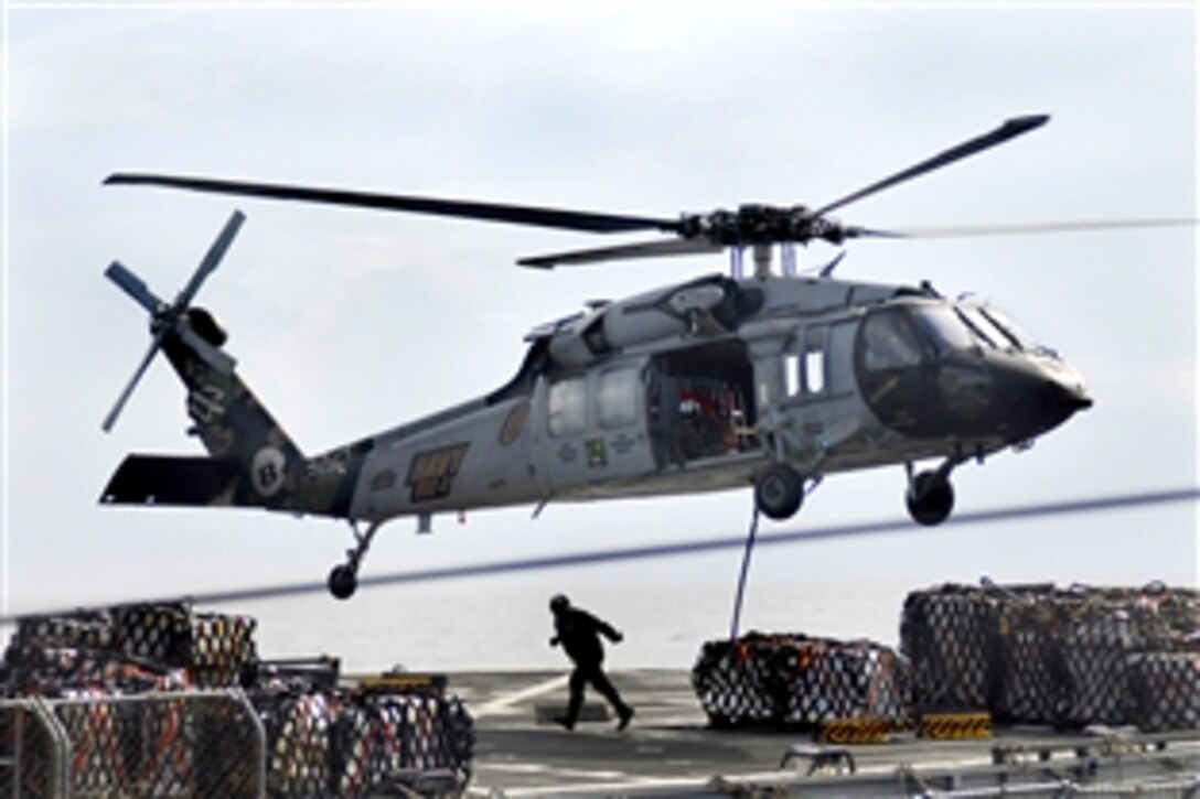 An MH-60S Sea Hawk helicopter lifts supplies from the Military Sealift Command combat stores ship USNS San Jose during a replenishment at sea with the aircraft carrier USS John C. Stennis in the Pacific Ocean, April 6, 2009.