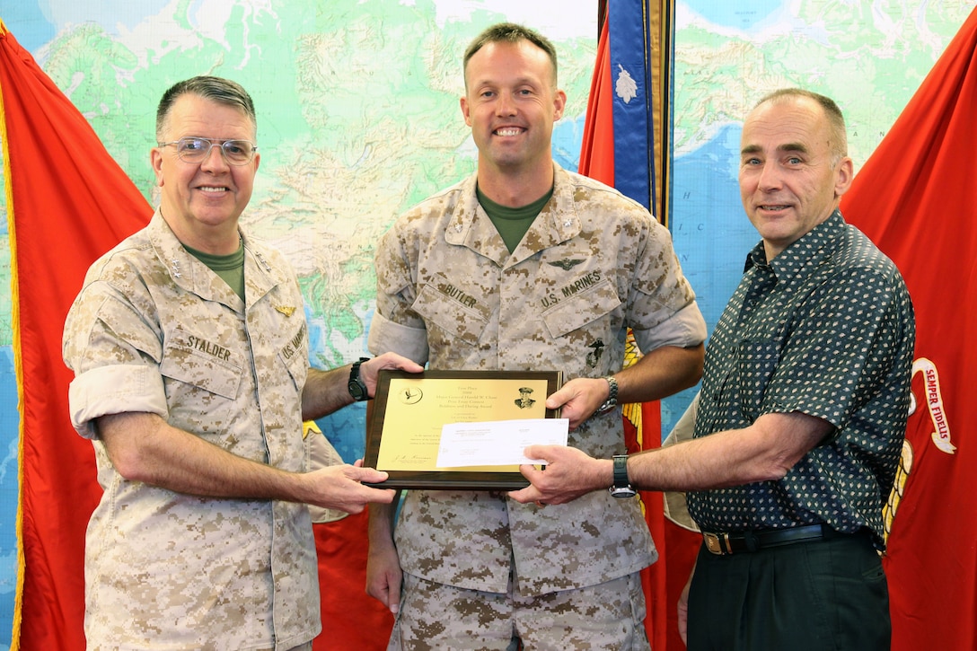 Lt. Gen. Keith J. Stalder, commander, U.S. Marine Corps Forces Pacific, (left) and retired Lt. Gen. Wallace Gregson, former commander, MarForPac, (right) present Lt. Col. Glen G. Butler, director of operations and training, Marine Corps Base Hawaii, (center) with a plaque and a $3,000 check for winning first place in the Marine Corps Gazette’s Maj. Gen. Harold W. Chase Prize Essay Contest here April 8