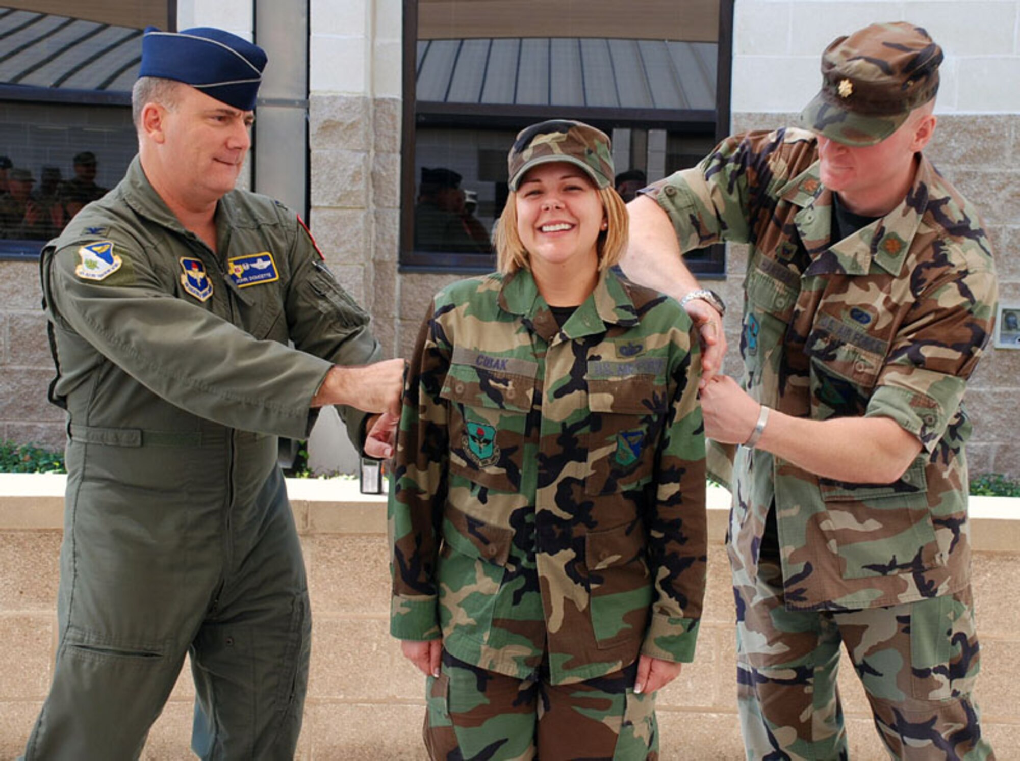 LAUGHLIN AIR FORCE BASE, Texas -- Tech. Sgt. Lori Cibak, 47th Comptroller Squadron, gets her fifth stripe punched on by Col. John Doucette, 47th Flying Training Wing commander and Maj. John Hansen, 47th CPTS commander, after being surprised about her STEP promotion here March 24. (U.S. Air Force photo by Airman 1st Class Sara Csurilla)