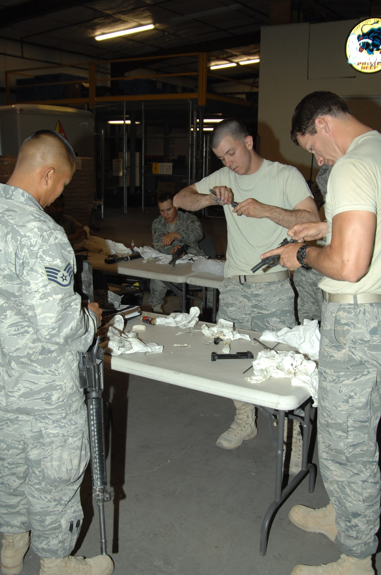 Staff Sgt. Carlo Mangoba (left), 1st Lt. Joseph DiRosario (middle) and Tech. Sgt. Kevin Shaver, all members of the 355th Civil Engineer Squadron here, clean their weapons before turning them into the armory upon their return April 6 from a six-month deployment to Southwest Asia. The team of CE Airmen worked with Rapid Engineer Deployable Heavy Operational Repair Squadron Engineer (RED HORSE) personnel to build support infrastructure in Afghanistan. For Sergeant Shaver, noncommissioned officer in charge of the deployed CE team, it was his third such deployment in the last four years. His wife, Allison, said it never gets easier, she never stops missing or worrying about her husband, but she's proud of him nonetheless. "He's obviously a great leader and mentor," she said. "We need NCOs like him over there." (U.S. Air Force photo/Staff Sgt. Jake Richmond)