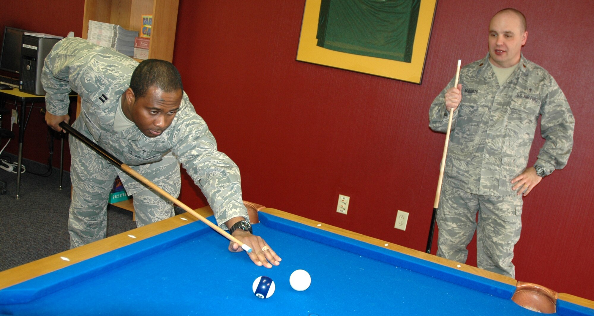 Chaplain (Capt.) Corwin Smith, 341st Missile Wing chaplain, and Chaplain (Maj.) Mark Roberts, 341st MW chaplain, play a game of pool during re-opening night at the Detour Airmen's center April 2. (U.S. Air Force photo/Senior Airman Dillon White)