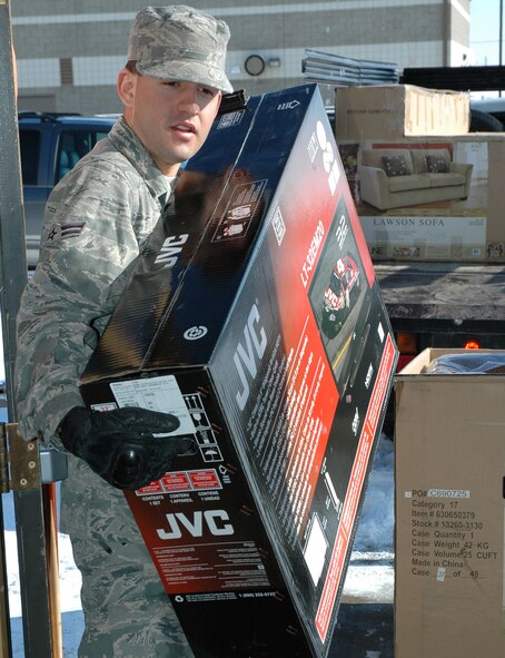 Airman 1st Class Anthony Melendez, 341st Missile Maintenance Squadron electro-mechanical team member, carries a new flat screen TV into the Detour Airmen's center March 30. Airmen volunteers helped carry in, and set up seven new TVs, three new couches and six new chairs with ottomans. The Airmen also helped paint the interior walls of the Detour to match the new furnishings. (U.S. Air Force photo/Senior Airman Dillon White)
