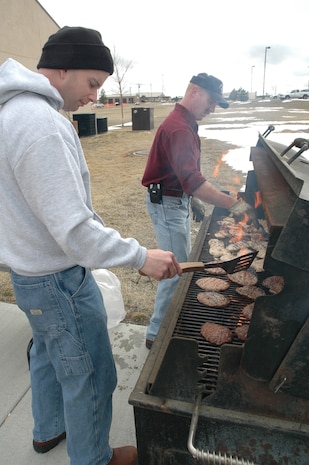 Master Sgt. Matthew Brenholt, 341st Medical Group first sergeant, and Master Sgt. John McMullen, 341st Civil Engineer Squadron first sergeant, man the barbeque at the Detour Airmen's center during the re-opening April 2. The Malmstrom First Sergeant's Council grilled more than 200 hamburgers, hot dogs and chicken breasts provided with money from the Enforcing Underage Drinking Laws grant. (U.S. Air Force photo/Senior Airman Dillon White)