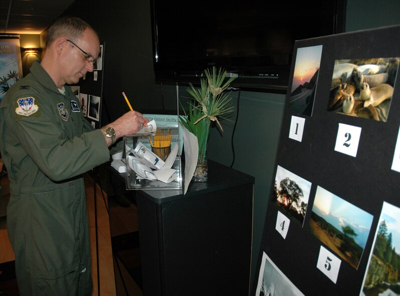 Col. Michael Fortney, 341st Missile Wing commander, fills out his vote for the best photograph in a photography contest at the re-opening of the Detour April 2. The top three winners of the photography contest were: first place, Airman 1st Class Sonya Young; second place Airman Eric Chapin; third place Airman 1st Class Anthony Melendez. There photos will be enlarged and displayed at the Detour. (U.S. Air Force photo/Dillon White)