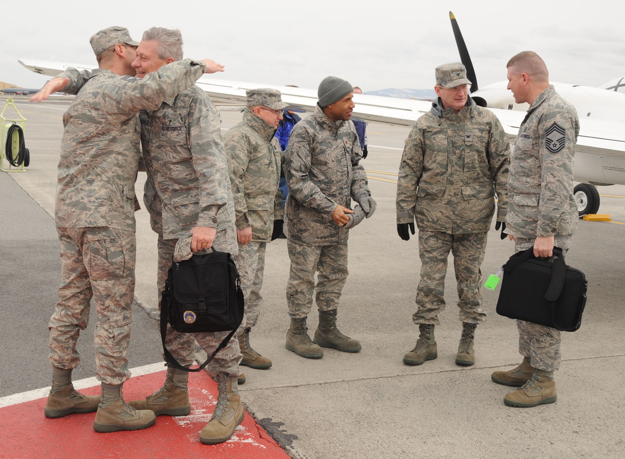 Col. Robert Thomas, 92nd Air Refueling Wing commander greets, Chief Master Sgt. Roger R. Dubois, Air Mobility Command chaplain assistant functional manager, as Major Kelvin Gardner and Capt. Erik Harp, 92nd Air Refueling Wing chaplains, look on. Col. Brian Van Sickle, Headquarters Air Mobility Command chaplain, extends a hug to Chief Master Sgt. 92nd ARW Command chief on April. 1. (U.S. Air Force photo/Staff Sgt. James May III)