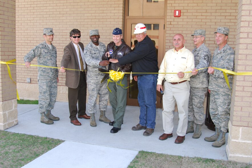 The Official Party including Brig. Gen. Darryl Roberson, 325th Fighter Wing commander, Col. David Zeh, 325th Mission Support Group commander, Lt. Col. Keith Welch, 325th Civil Engineer Squadron commander and Chief Master Sgt. Benjamin Van Vleet, 325th FW command chief master sergeant and Airman 1st Class Irving Lewis, dorm council president, accompanied by Marlon Kirkland, Army Corps of Engineers, Jeff Caddell, Caddell Construction Inc., Steve Lancer, project superintendent, cut the ribbon to the new “Dorms-4-Airmen” Tuesday, marking the completion of construction.  (U.S. Air Force photo by Lisa Norman)