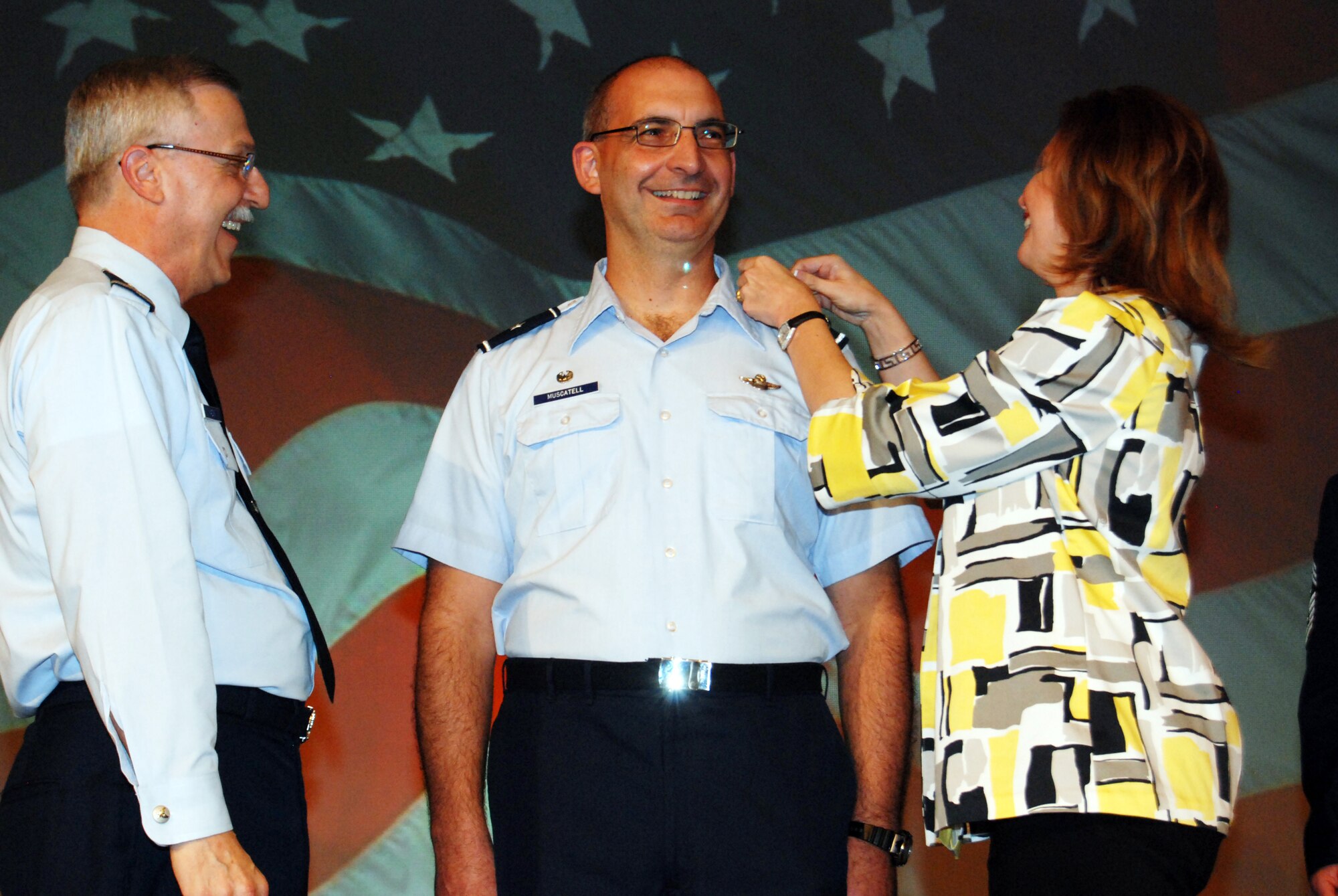 Maj. Gen. Martin M. Mazick, former 22nd Air Force commander, watches Nancy Muscatell put a star on her husband, Brig. Gen. James Muscatell, commander, 403d Wing, during the 22nd Air Force Senior Leaders Conference 2009 April 3 in Atlanta. General Muscatell was promoted on the spot prior to the 22nd AF change of command. (U.S. Air Force photo/2nd Lt. Joe Simms)