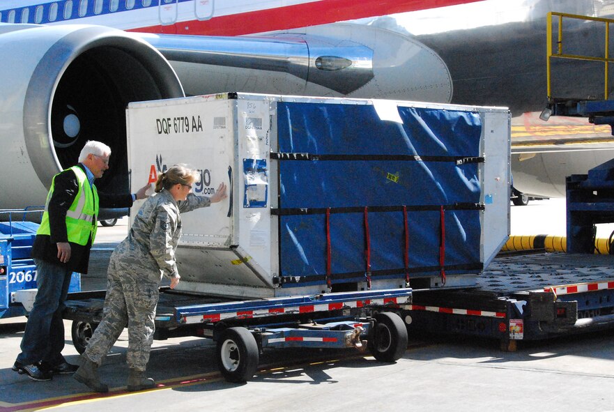 Alan Burks, Unsung Heroes founder, and Air Force Reservist Tech. Sgt. Julie Briden-Garcia, 301st Fighter Wing Public Affairs NCOIC, help load the first box on to the aircraft bound for Iraq. American Airlines, Operation Iraqi Children, Armed Forces Entertainment and the Unsung Heroes Fund have joined forces to send over 20 tons of school supplies, Croc shoes and soccer balls for the Iraqi children, in addition to entertainers, snacks and other supplies for U.S. servicemembers. This endeavor is an effort to show support for our military members serving in Iraq and to help these servicemembers reach out to the Iraqi children. (U.S. Air Force Photo/Laura Dermarderosian-Smith)