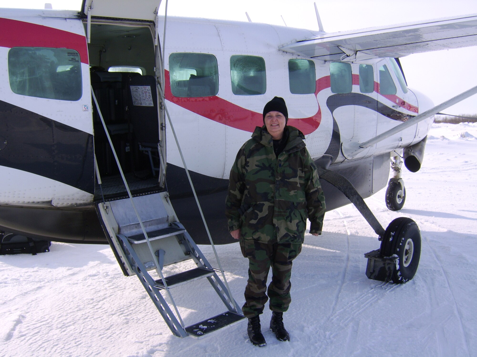 Lt. Col. Cheryl Hooper stands next to a charter plane that flew her to Bethel, Alaska, the staging point of a mission she returned from in late March. She went to Alaska in support of Operation Arctic Care, an annual military medical readiness exercise that brings no-cost health care to underserved residents of rural Alaska. Colonel Hooper is the commander of the 931st Aerospace Medicine Flight, an Air Force Reserve unit at McConnell Air Force Base, Kan. (Courtesy photo)
