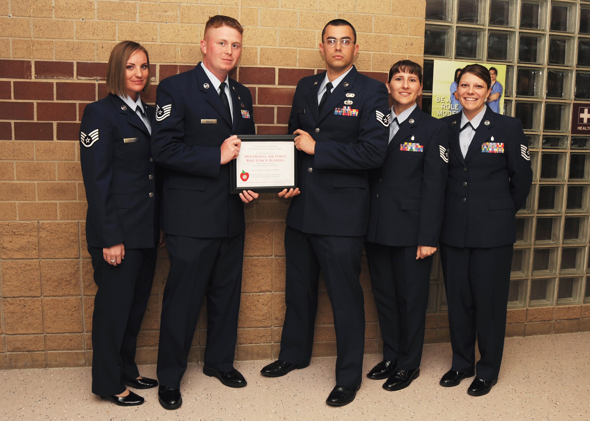 MULVANE HIGH SCHOOL, Kan. -- From left, Staff Sgt. Sara Margaret Stevens, 22nd Comptroller Squadron, Tech. Sgt. Brandon Swalla, 22nd Force Support Squadron, Staff Sgt. Ronald Lafosse, 22nd Air Refueling Wing Public Affairs, Tech. Sgt. Tiffany Shaffer, 22nd Medical Operation Squadrons, and Tech. Sgt. Kristy Earls, 22nd Aerospace Medical Squadron, executive council for Route 56, receive a certificate of appreciation from Derby United School District 260 for McConnell Air Force Base, April 4. The certificate was awarded for the Wineteer Elementary School and McConnell AFB lunch buddies program.   (Photo by Airman 1st Class Maria Ruiz)