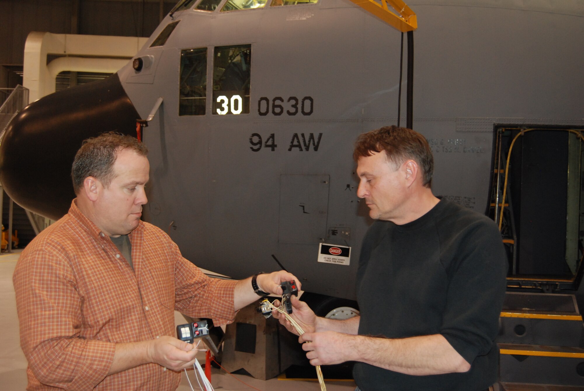 DOBBINS AIR RESERVE BASE,  Ga. -- Air Reserve Technician Dave Metroka, 94th Airlift Wing Avionics/Munitions Flight, right, and Greg Johnson, E.J.M. Aerospace Services from Crestview, Fla., inspect  a new switching system being installed in a Dobbins ARB C-130 aircraft during a test modification program April 7.  The modification should increase a pilots and co-pilots ability to dispense chaff and flares. (U.S. Air Force photo/Jim Weslowski)