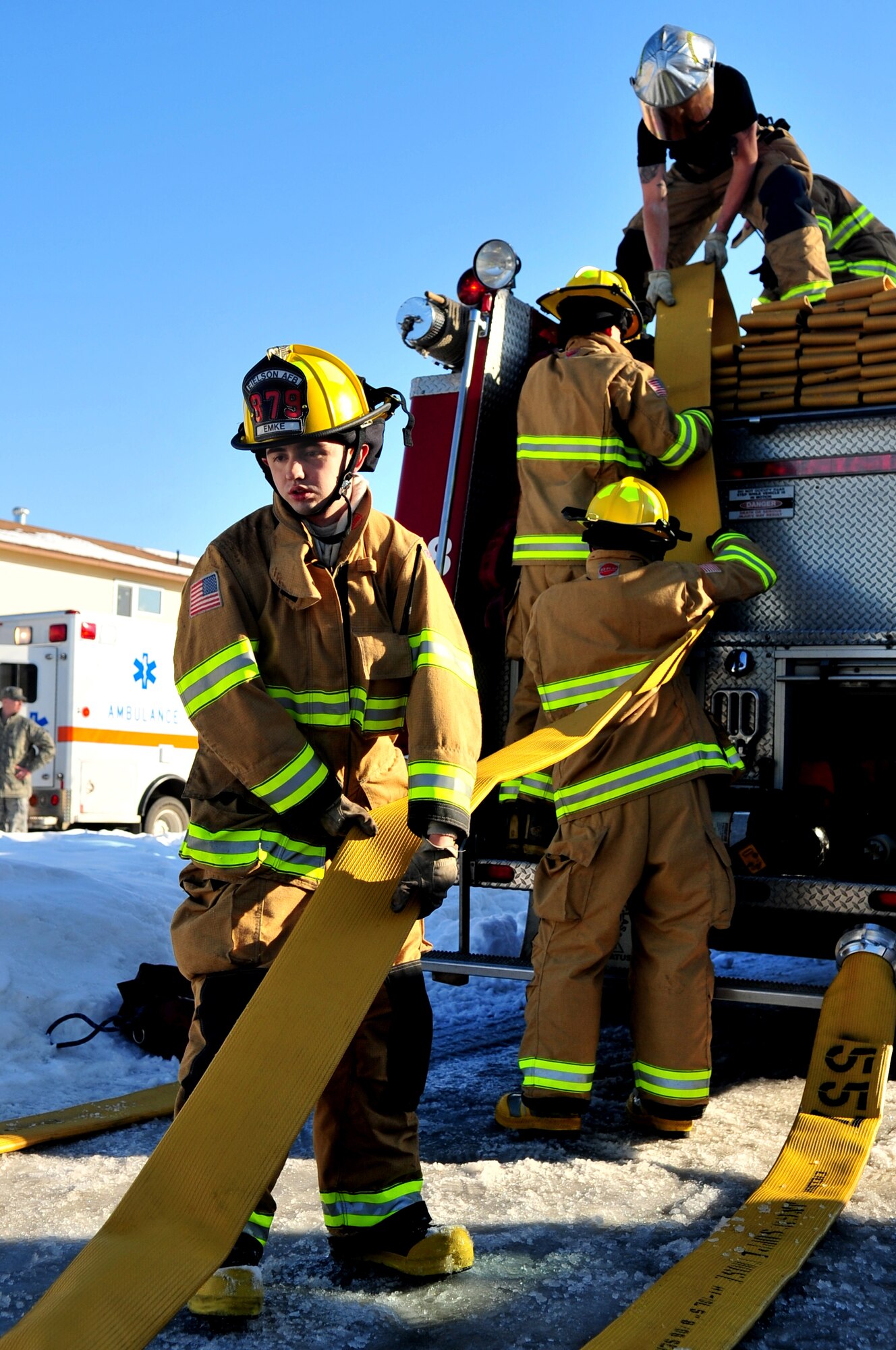 EIELSON AIR FORCE BASE, ALASKA -- Airman from the Eielson AFB Fire Department roll up fire hoses after responding to a fire at an on-base residence Apr. 6. Firefighters responded to the scene within five minutes and helped mitigate property damage. (U.S. Air Force photo/Senior Airman Christopher Boitz)