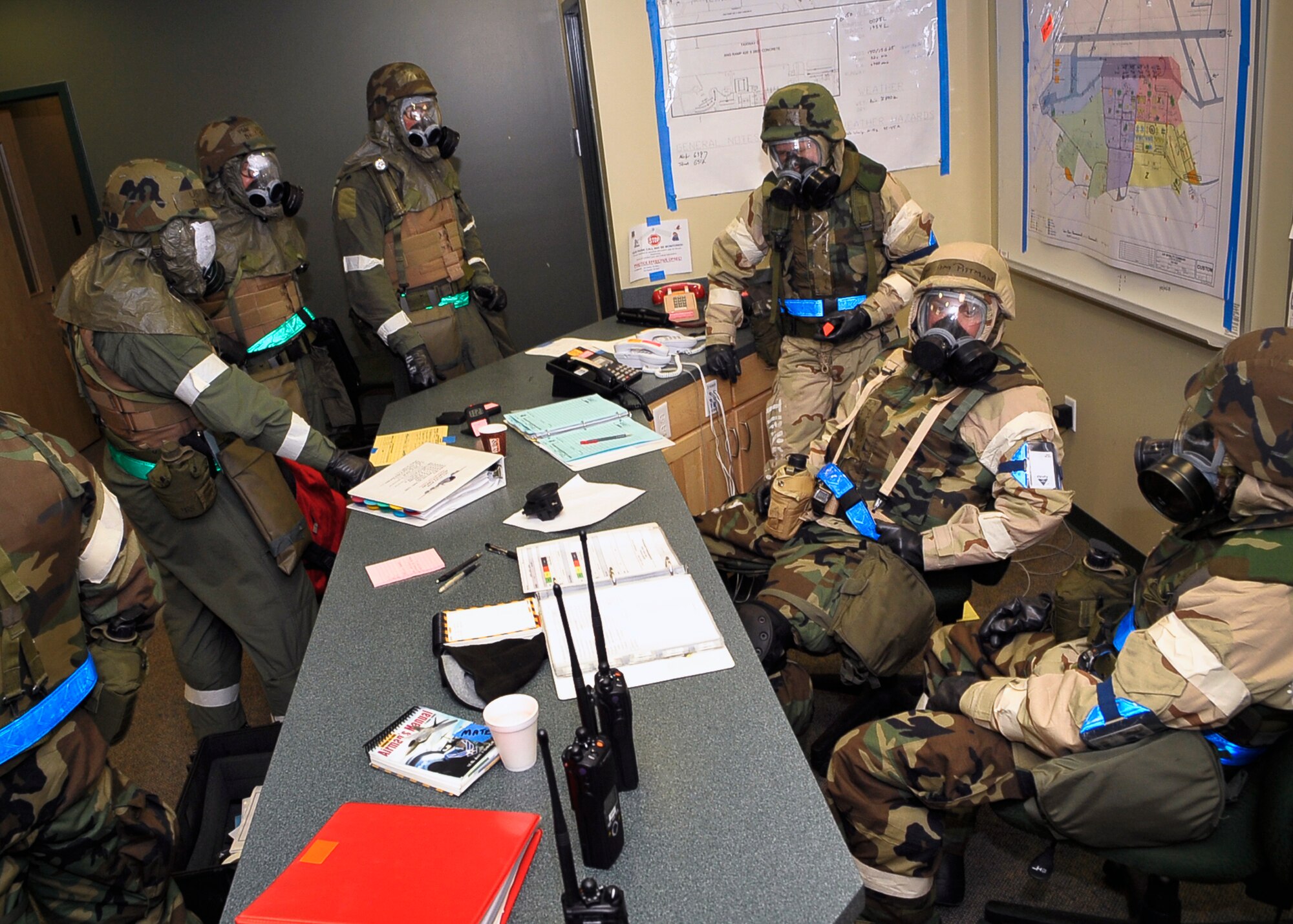 92nd Operations Group Airmen discuss logistics after a simulated base attack here March 25. Members wore special chemical warfare suits as part of routine protective measures after an attack. (U.S. Air Force photo / Senior Airman Joshua K. Chapman)